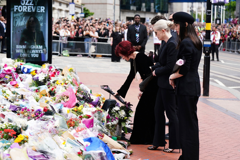 Sharon Osbourne is supported by her children Jack, Kelly and Aimee Osbourne as they lay and view the flowers left at the Black Sabbath Bridge bench on Broad Street in memory of Black Sabbath frontman Ozzy Osbourne ahead of his funeral procession, in Birmingham, England.