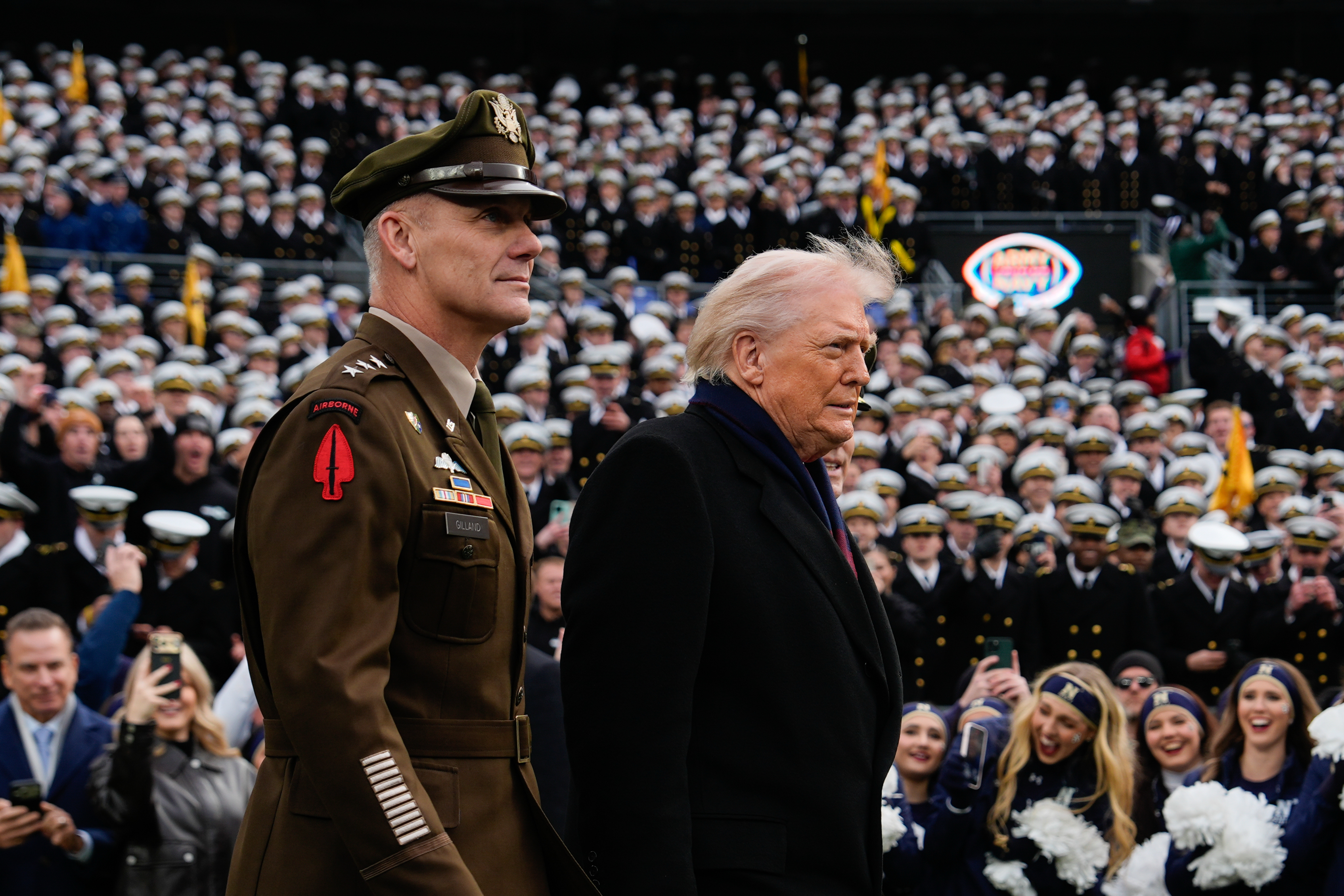 President Donald Trump walks onto the field with Lt. Gen. Steven Gilland, Superintendent of the U.S. Military Academy at West Point, left, and Lt. Gen. Michael Borgschulte, Superintendent of the U.S. Naval Academy, right, before the start of the 126th Army-Navy NCAA college football game at M&T Bank Stadium, Saturday, Dec. 13, 2025, in Baltimore. 