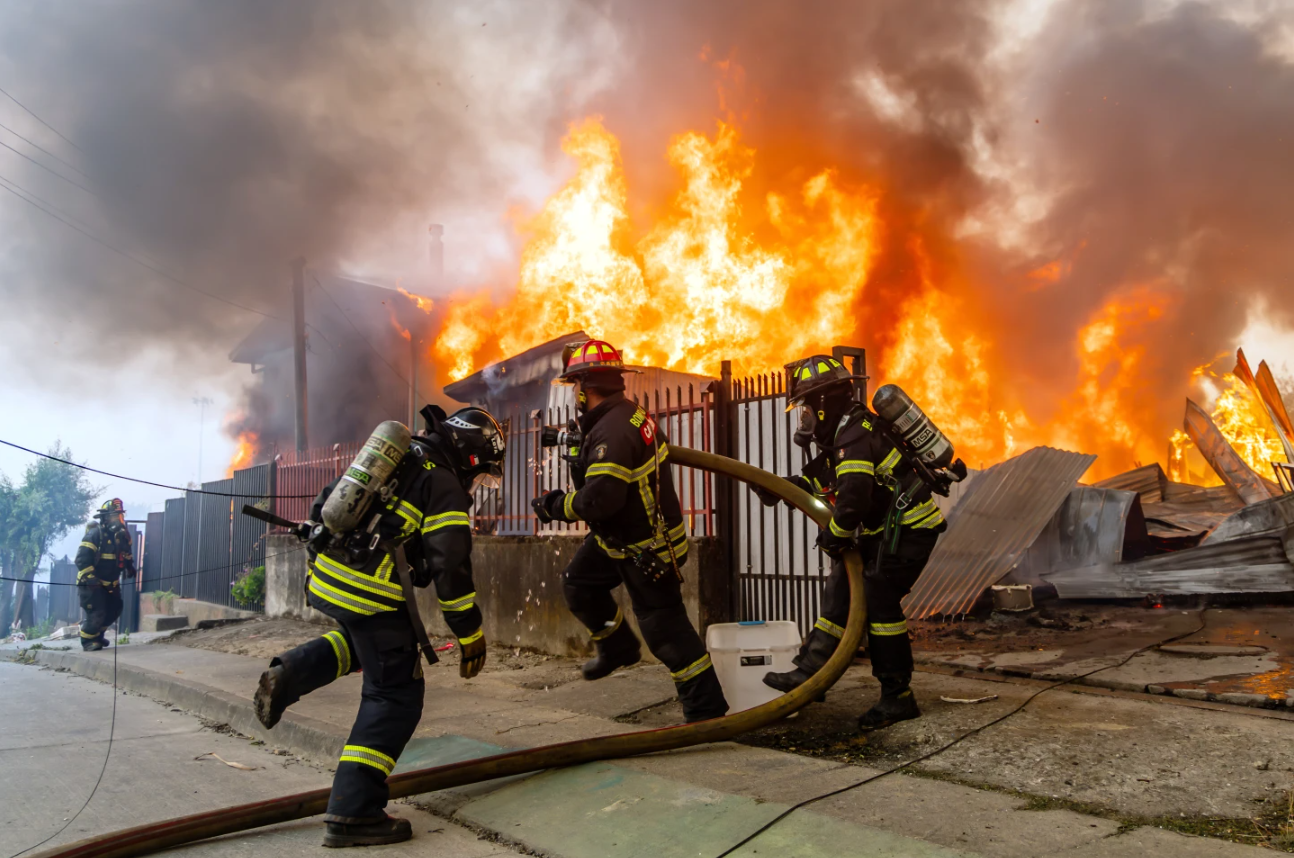 Firefighters battle a blaze at a house as wildfires burn in Lirquen, Chile, Sunday, Jan. 18, 2026. 