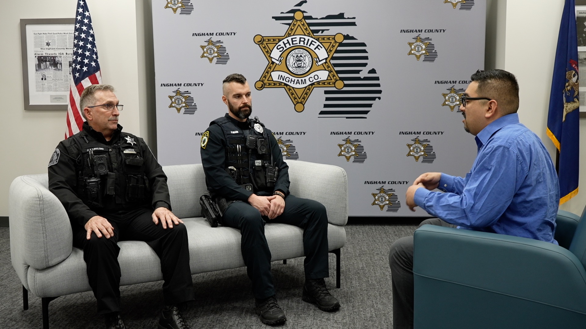 Danny Valle sits with first responders who helped rescue Lansing man from burning car