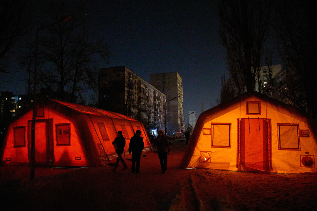 People walk past emergency tents set to warm up in Kyiv, Ukraine, Wednesday, Jan. 21, 2026, following Russia's regular air attacks on the country's energy system that leave residents without power, water and heating. 