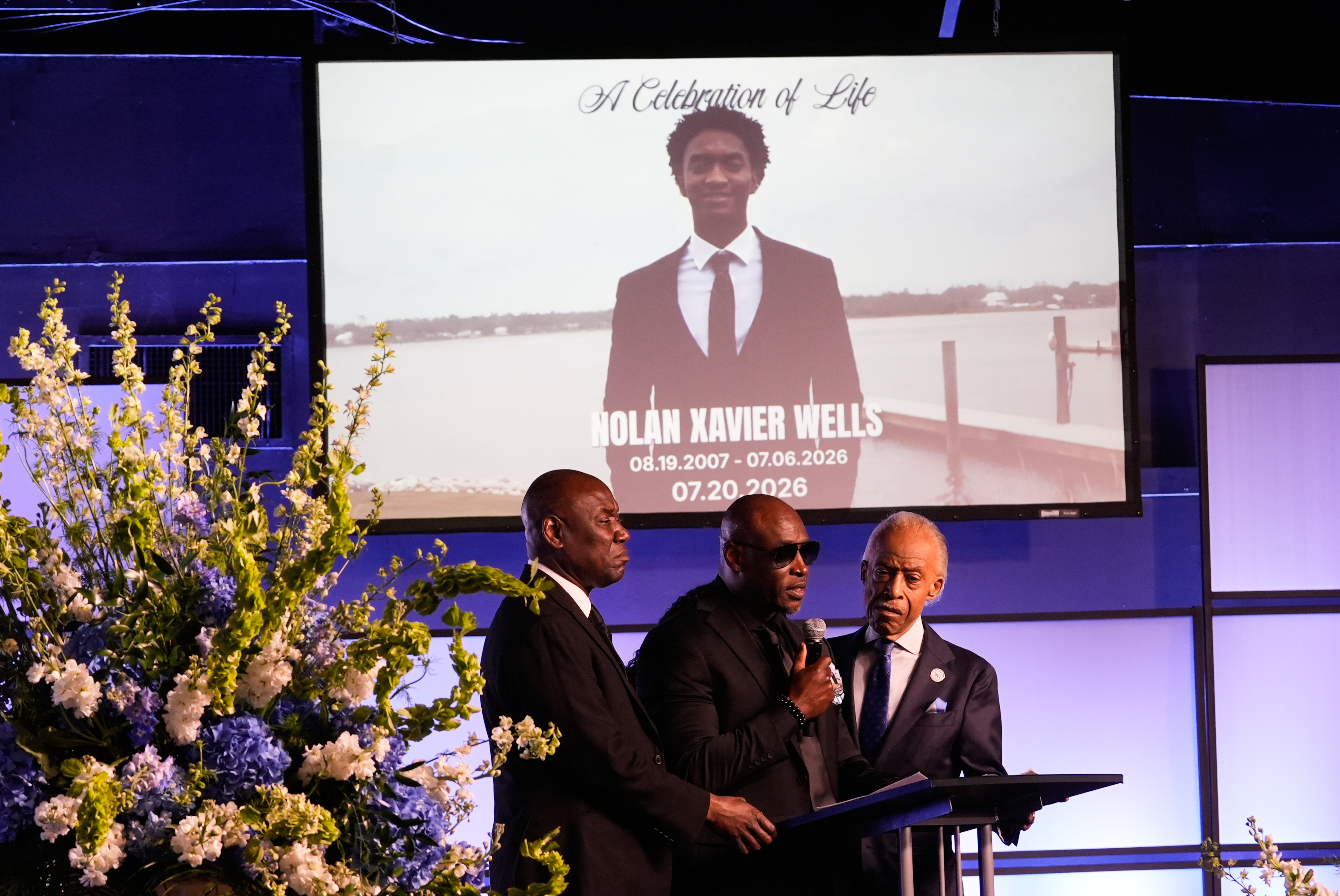 Elmore Wonsley, center, speaks next to attorney Ben Crump, left, and Rev. Al Sharpton during a memorial service for Nolan Xavier Wells, an 18-year-old found dead after taking a July 4 boat trip with friends, Monday, July 20, 2026, in Ocean Springs, Miss. 