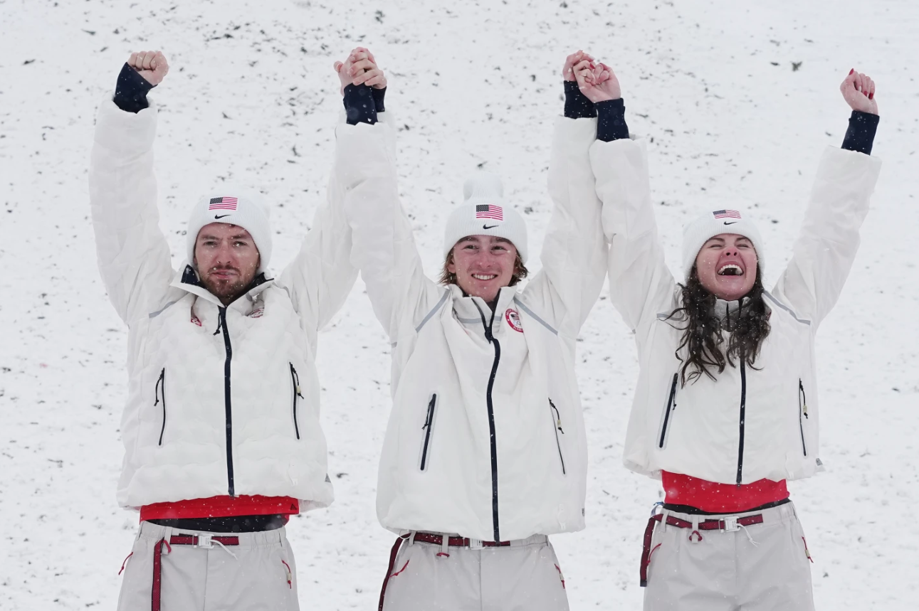 From left, gold medalists United States' Christopher Lillis, Connor Curran and Kaila Juhn celebrate after the freestyle skiing mixed team aerials final at the 2026 Winter Olympics, in Livigno, Italy, Saturday, Feb. 21, 2026.