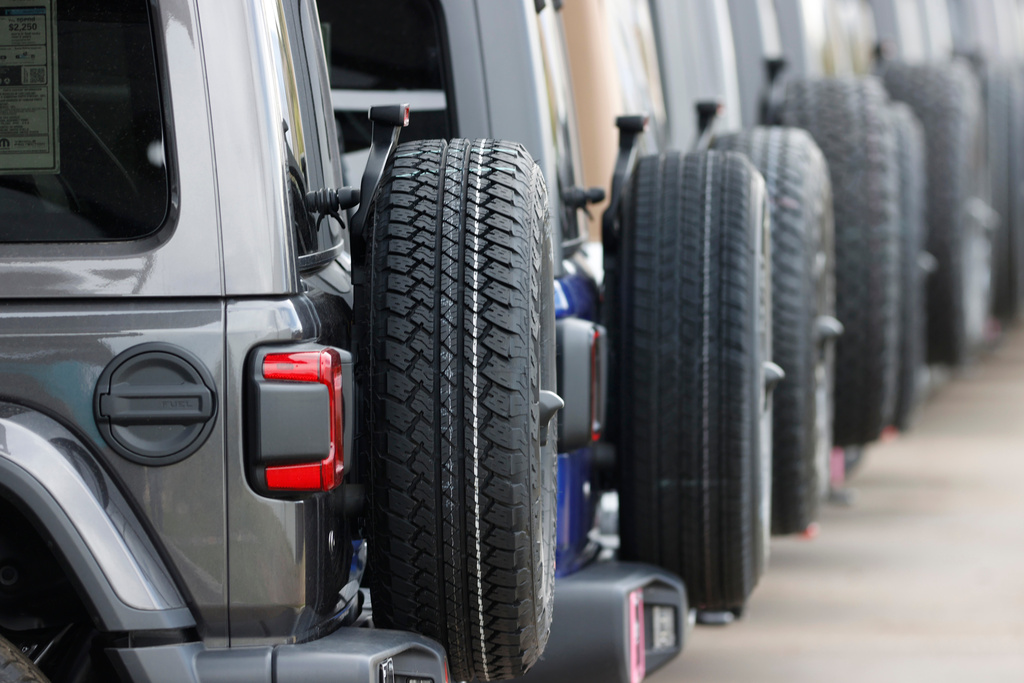FILE - Spare tires are seen on a long row of unsold 2020 Wranglers sit at a Jeep dealership in Englewood, Colo., on April 26, 2020.