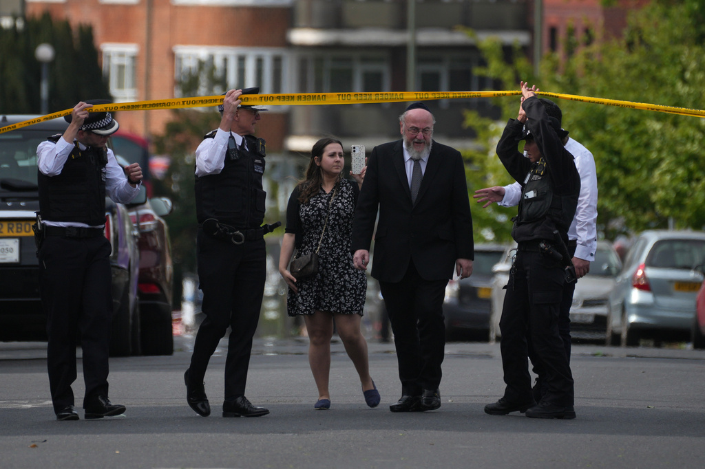 Police officers open the cordon for Chief Rabbi Ephraim Mirvis after two people were stabbed in Golders Green neighborhood, that has a large Jewish community, in London, Wednesday, April 29, 2026.