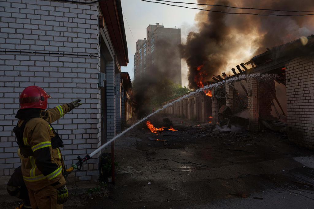 Rescue workers put out a fire of a car workshop damaged after a Russian strike on Kyiv, Ukraine, on Tuesday, June 2, 2026. 