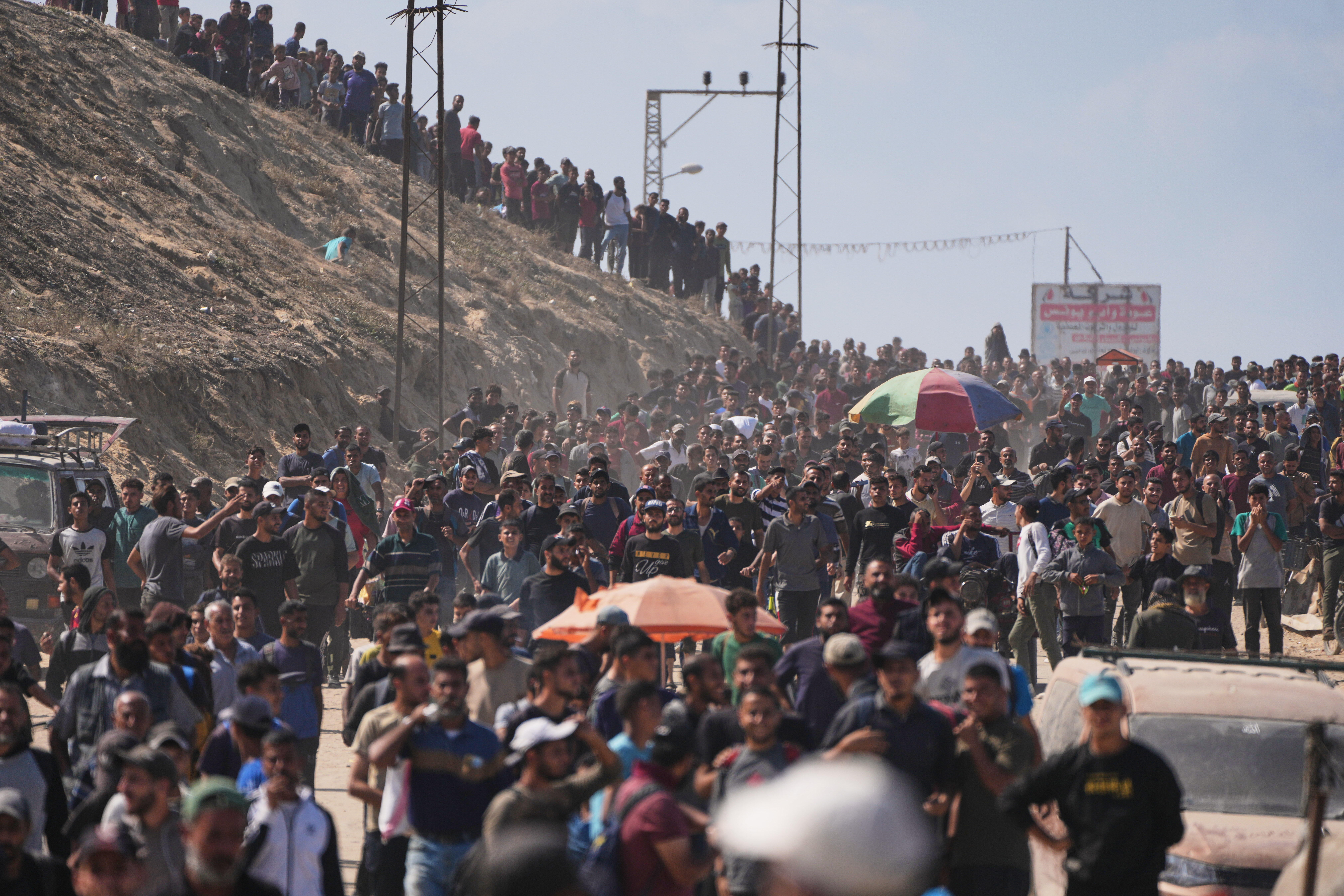 Displaced Palestinians walk along the coastal road near Wadi Gaza in the central Gaza Strip, moving toward northern Gaza, Friday, Oct. 10, 2025, after Israel and Hamas have agreed to a pause in their war and the release of the remaining hostages. 