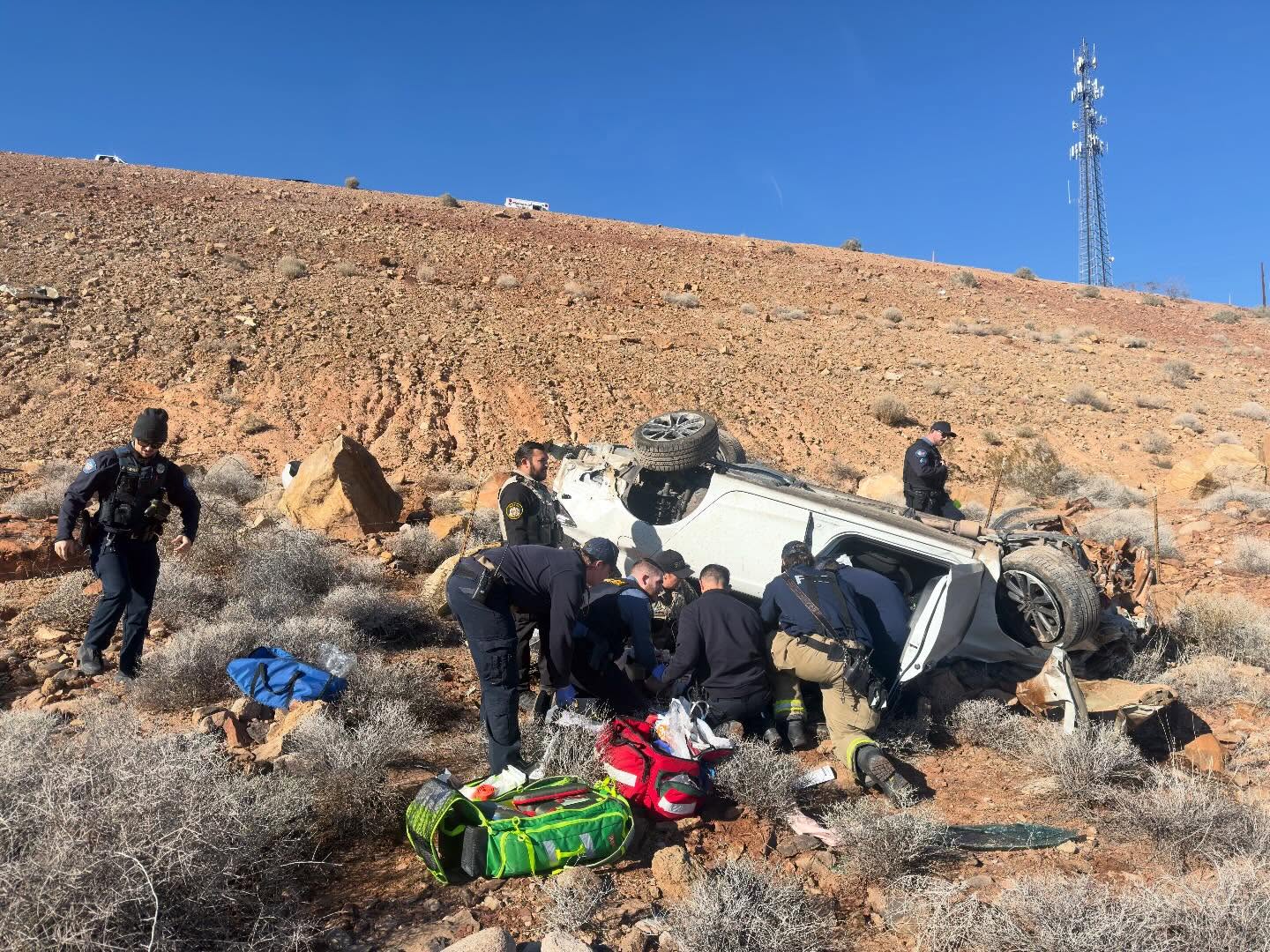 A photo of the scene released by Hurricane Valley Fire & Rescue. It's daytime, and responders work to extricate the driver of the rolled over vehicle.
