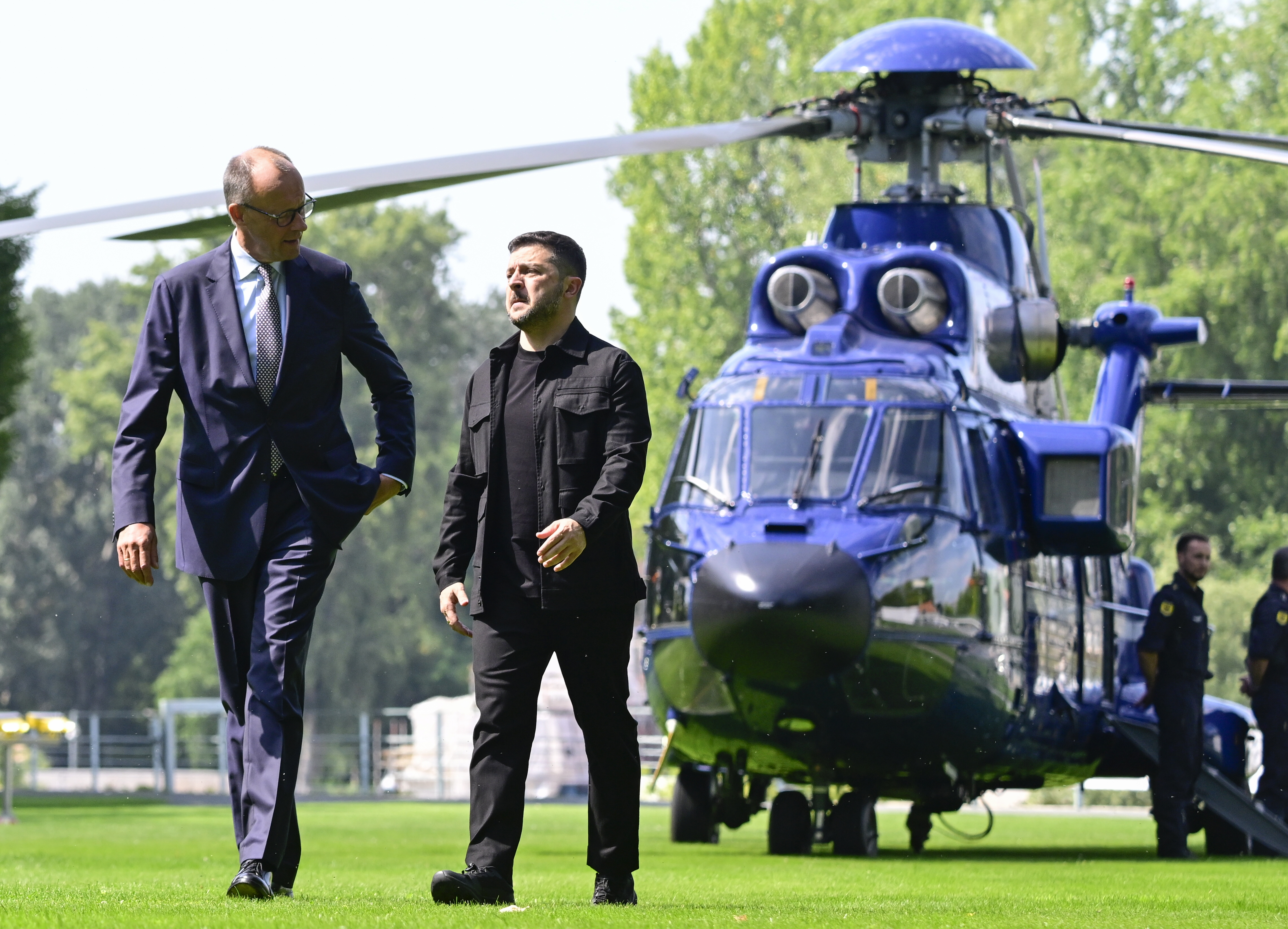 Ukrainian President Volodymyr Zelenskyy, front right,  is welcomed by German Chancellor Friedrich Merz, left, upon arrival in the garden of the chancellery in Berlin, Germany, Wednesday, Aug. 13, 2025 to join a video conference of European leaders with the US President on the Ukraine war. 