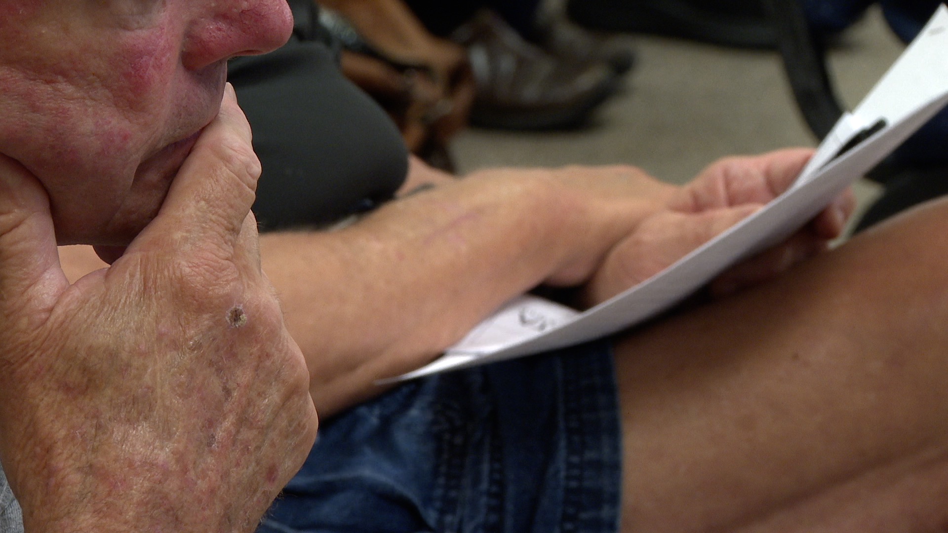 Man with hand on chin during meeting on Delta Township police safety assessment proposal