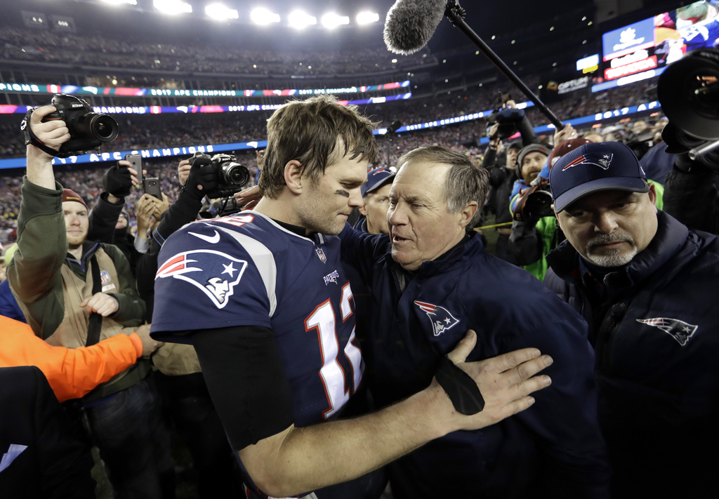 New England Patriots quarterback Tom Brady, left, hugs coach Bill Belichick