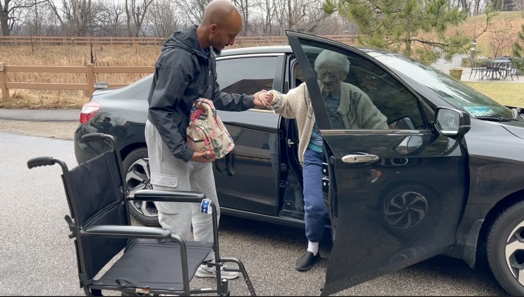 Driver helps woman out of a car.jpeg