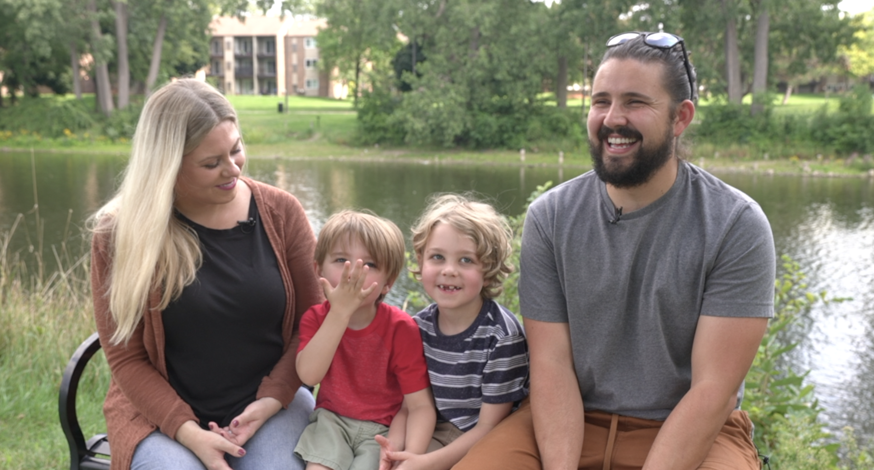 Morgan, Jude, Jonah and Chris sitting on a bench at Adado Riverfront Park in Lansing 