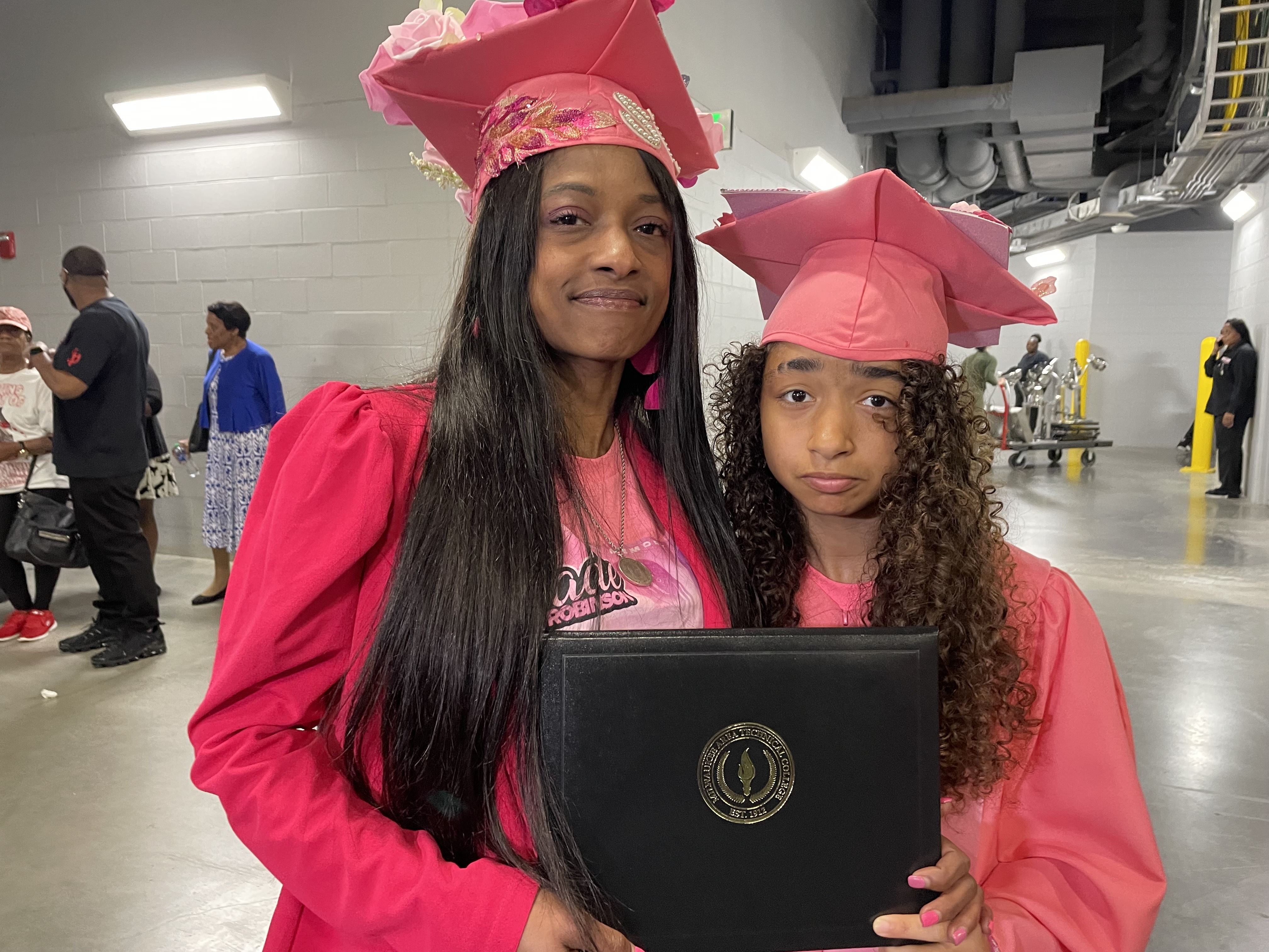 Sade Robinson's mom Sheena Scarbrough and sister Adrianna Reams hold Robinson's posthumous honorary degree from MATC