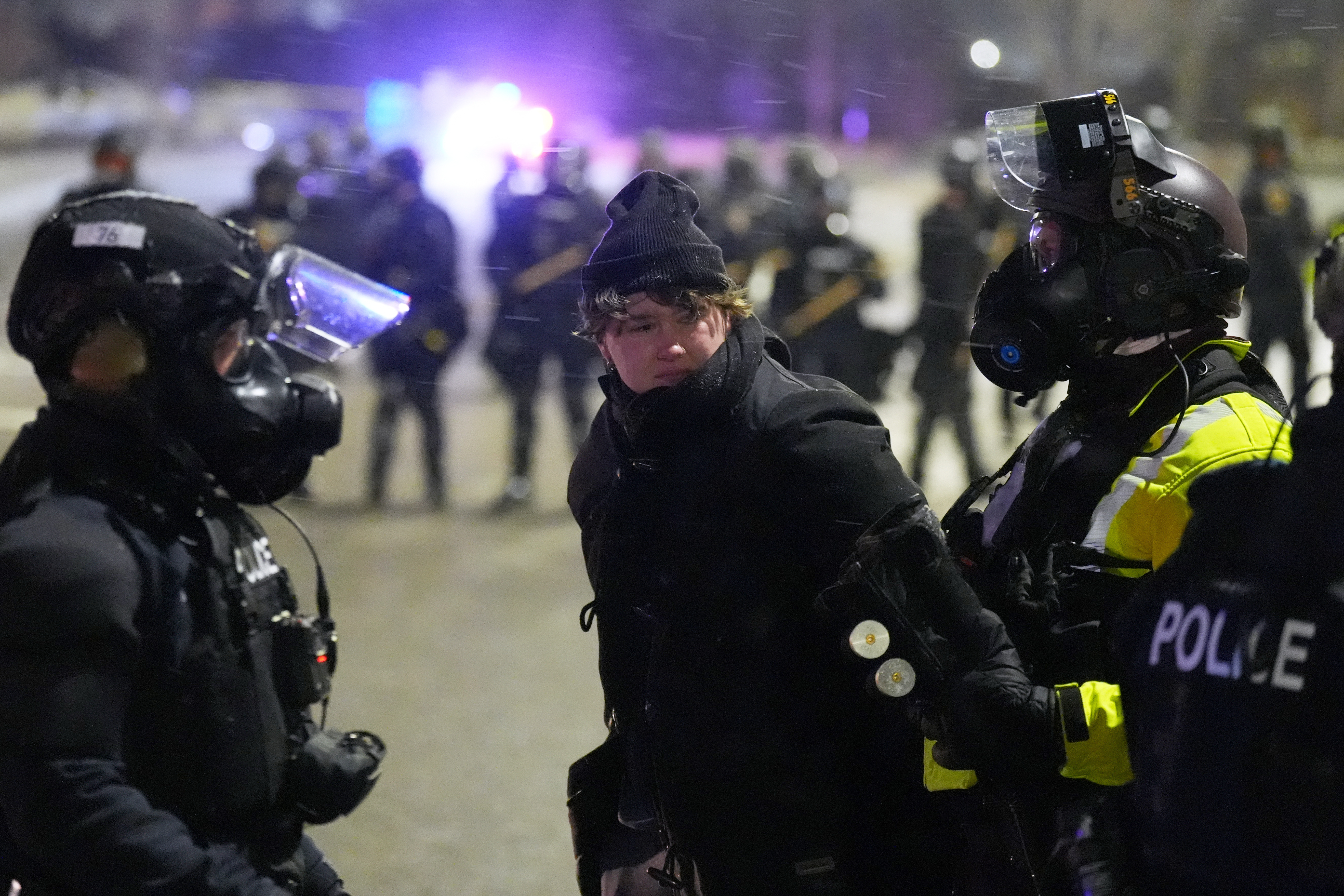 Law enforcement officers detain a person during a protest outside SpringHill Suites and Residence Inn by Marriott hotels on Monday, Jan. 26, 2026, in Maple Grove, Minn