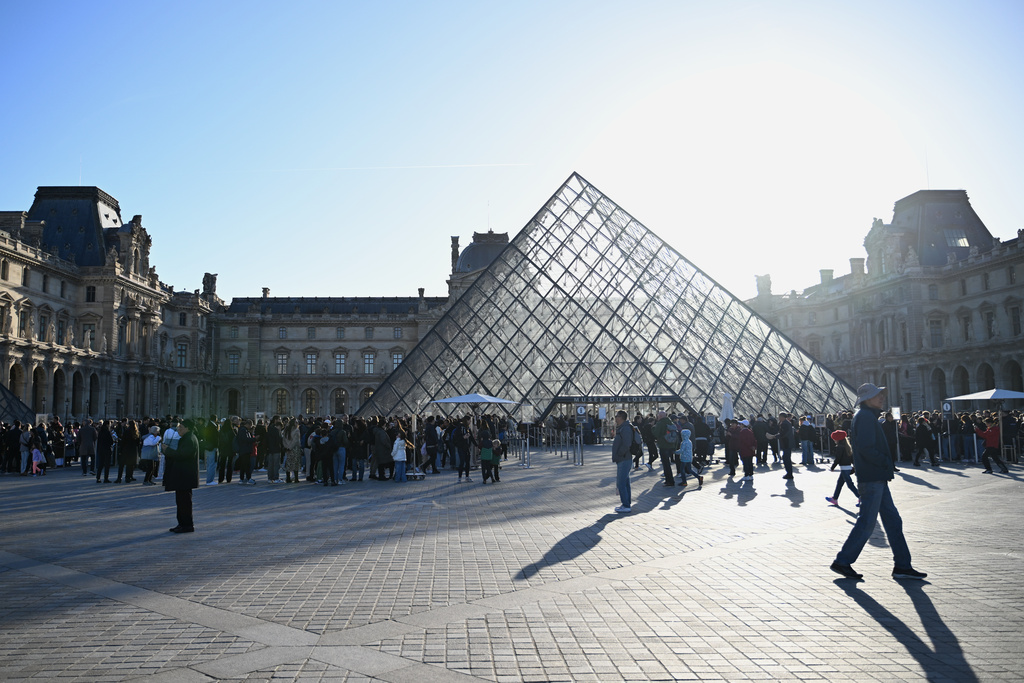 People queue to enter the Louvre museum, Thursday, Oct. 30, 2025 in Paris.