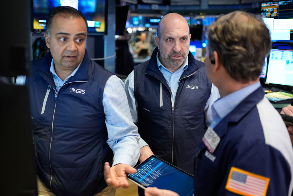 James Denaro, center, and Dilip Patel, left, work on the floor at the New York Stock Exchange in New York, Wednesday, March 25, 2026.