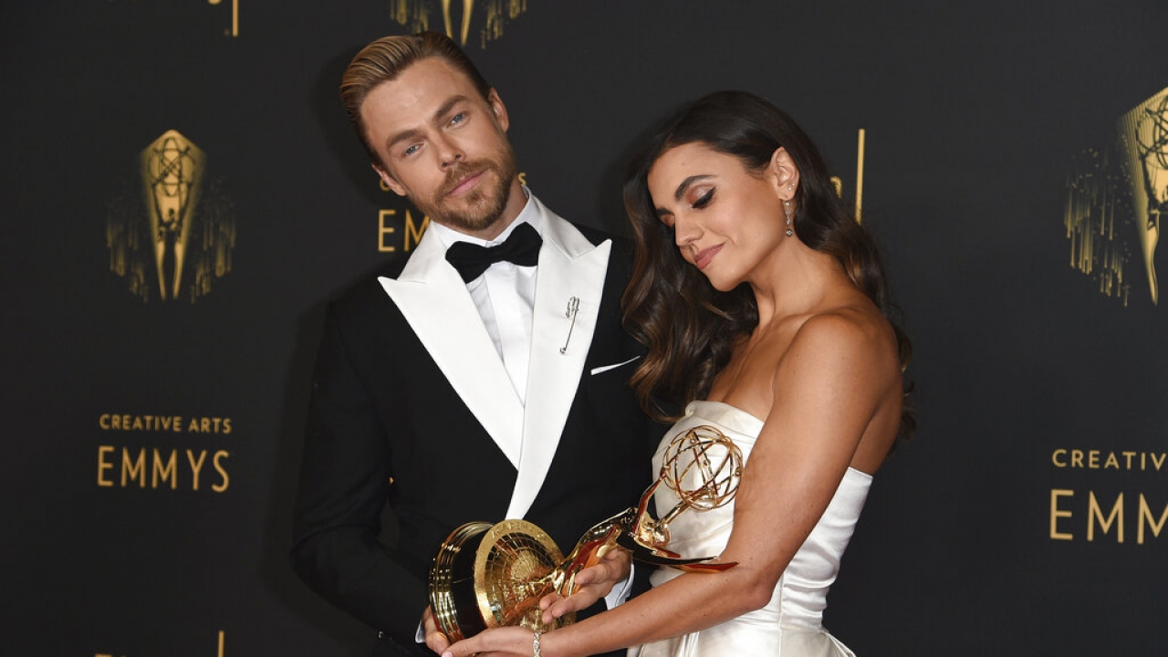Derek Houghand Hayley Erbert hold an Emmy they won for their choreography.