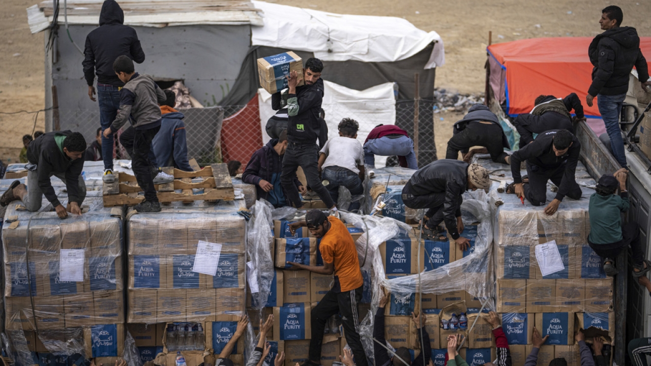 Palestinians loot a humanitarian aid truck as it crossed into the Gaza Strip in Rafah.