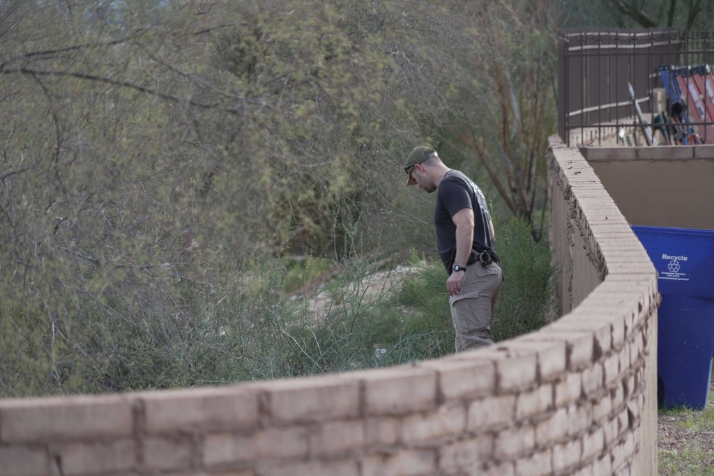 An investigator walks around homes in the neighborhood where Annie Guthrie, whose mother Nancy Guthrie has been missing for more than a week, lives just outside Tucson, Ariz., on Tuesday, Feb. 10, 2026. 