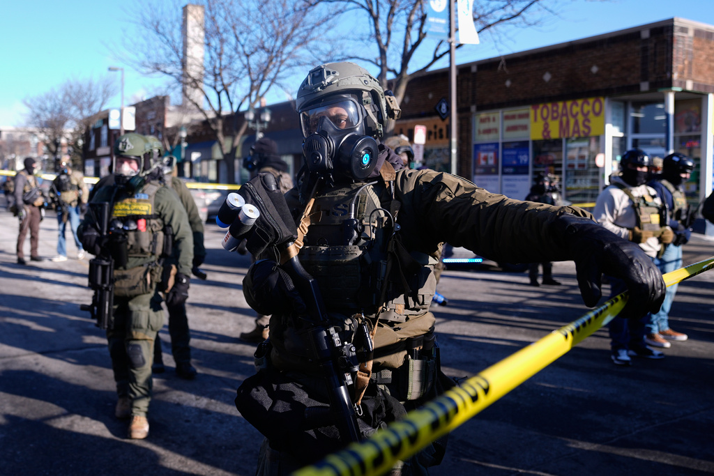 Federal agents stand near the site of a shooting Saturday, Jan. 24, 2026, in Minneapolis. 