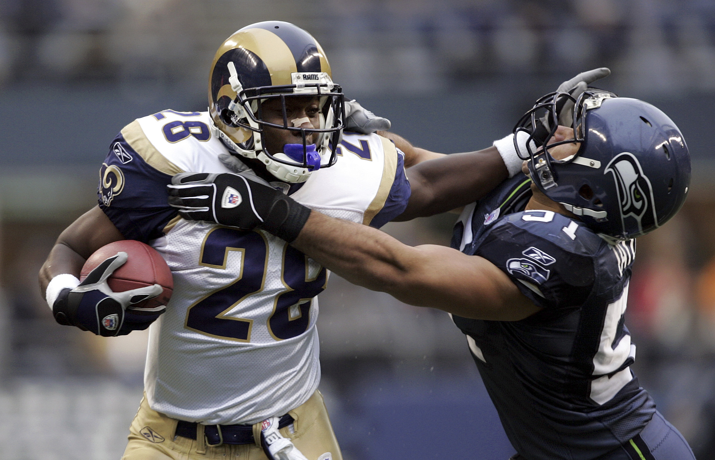 FILE - St. Louis Rams' Marshall Faulk, left, is pushed out of bounds by Seattle Seahawks' Lofa Tatupu on a second quarter, 15-yard pass reception, Sunday, Nov. 13, 2005, in Seattle. Faulk gained a first down on the play. 