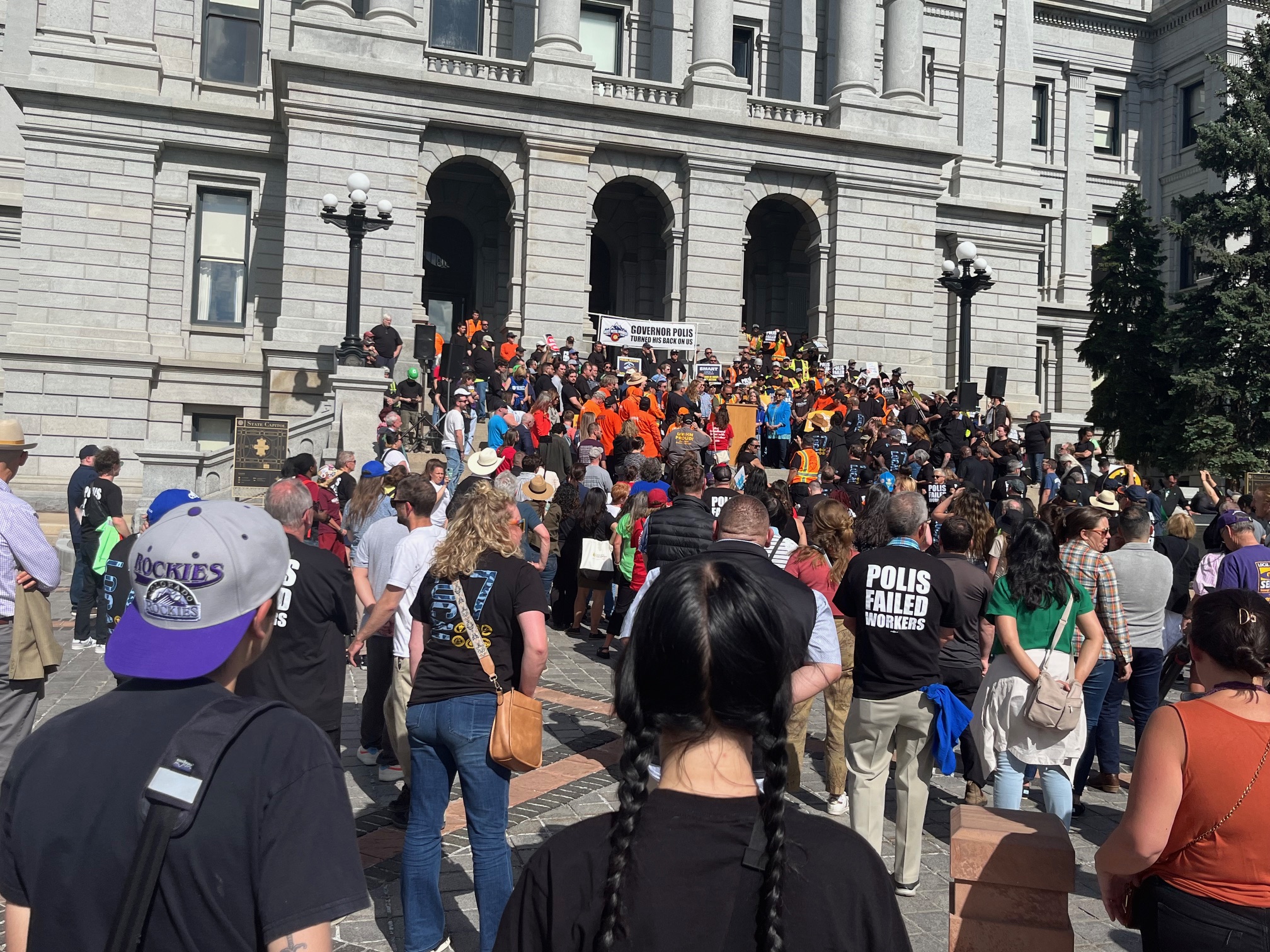 protestors on polis veto wage theft.jpeg