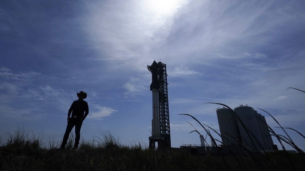 A man walks past the site where SpaceX's Starship, the world's biggest and most powerful rocket, sits ready for launch.