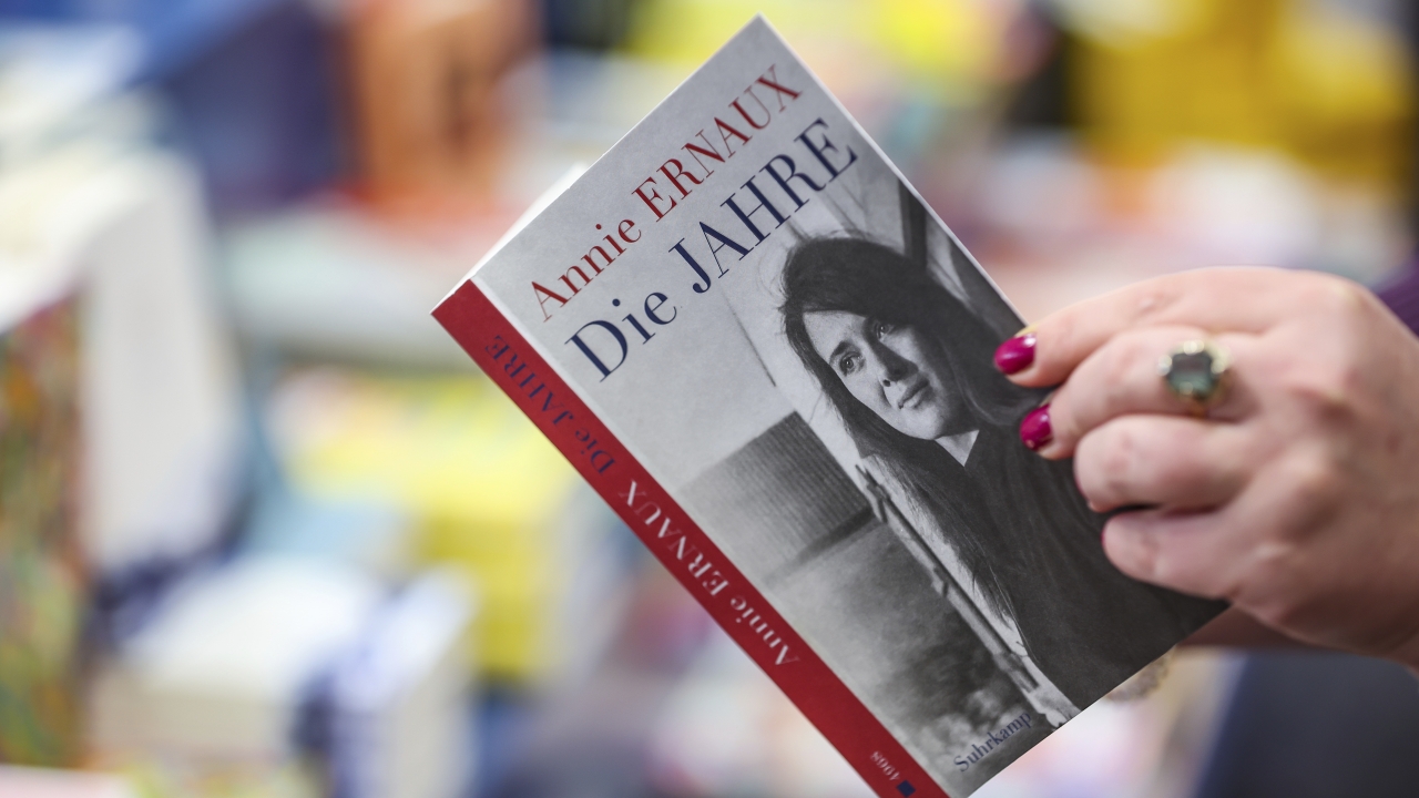 A woman holds the book "The Years" by Annie Ernaux in a bookstore