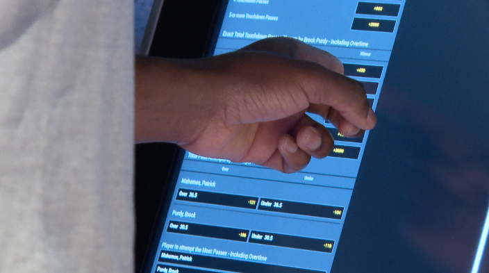person uses kiosk to bet on Super Bowl