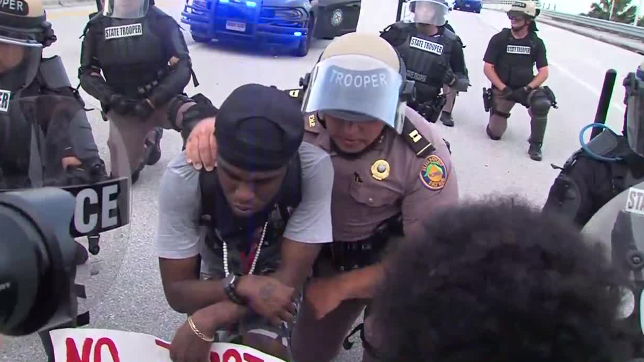 A Florida Highway Patrol trooper kneels in solidarity with a protester in Boca Raton, Fla., on June 1, 2020.