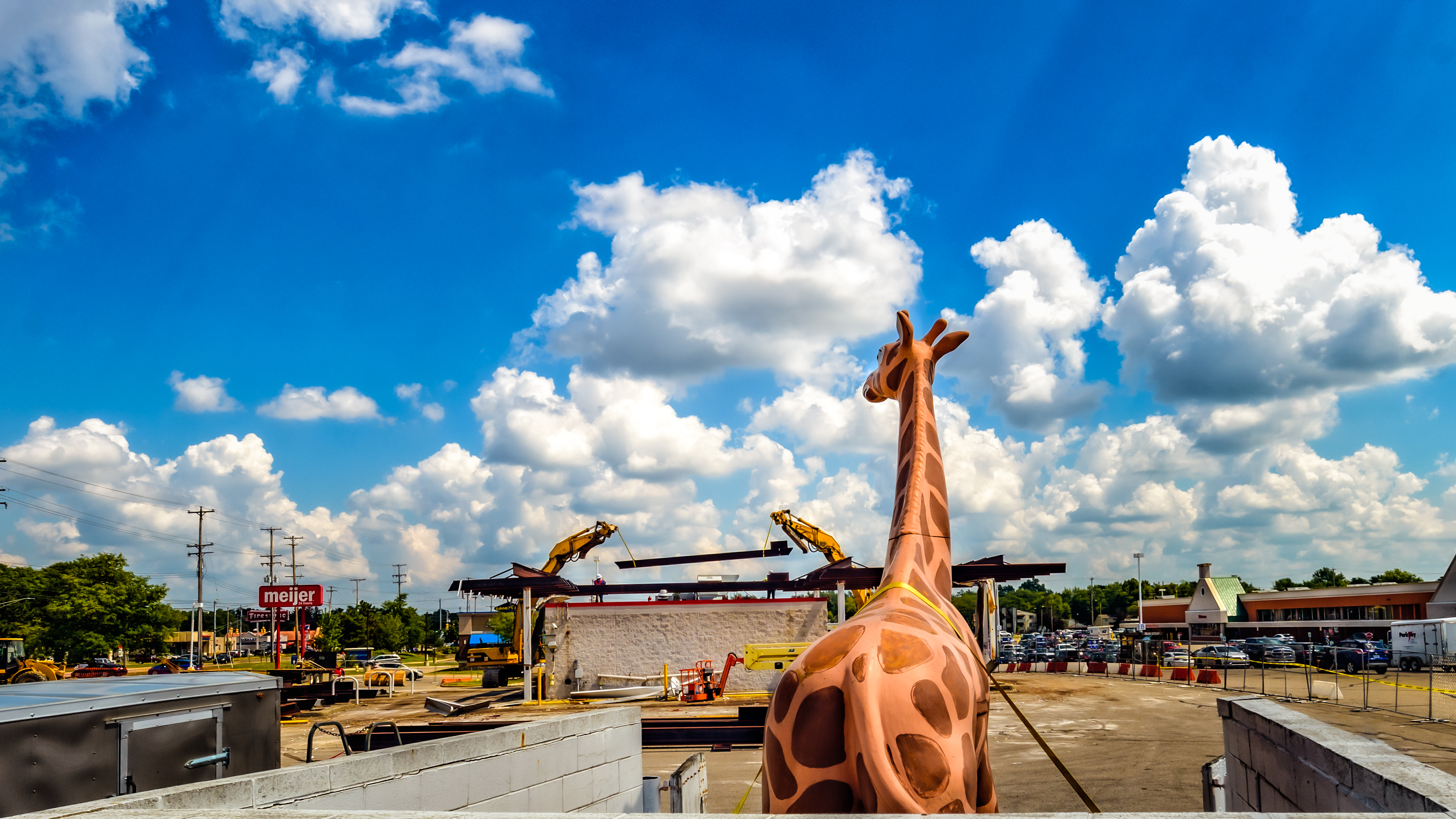 The giraffe that sat on top of the Meijer gas station on West Saginaw Highway is back after it was taken down about two weeks ago.