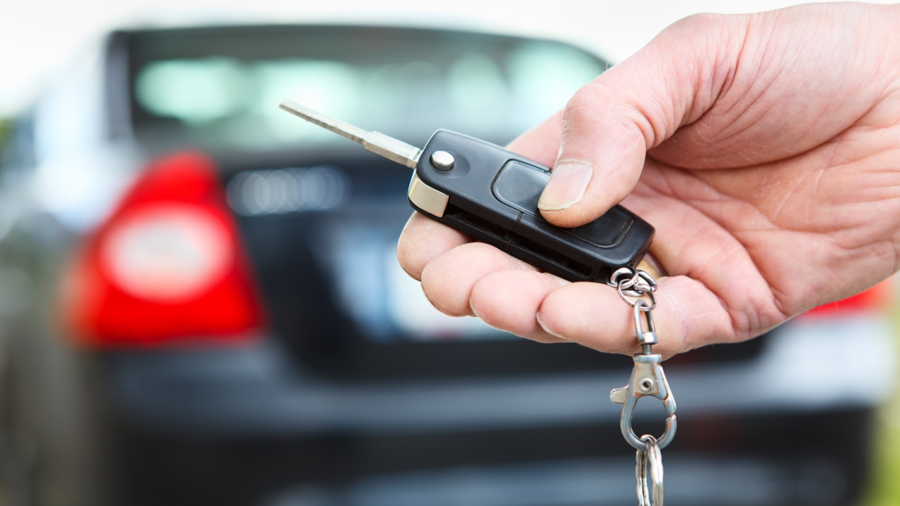 Men's hand presses on the remote control car alarm systems