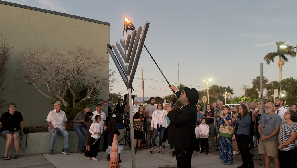 Rabbi Jacobson lighting the menorah 