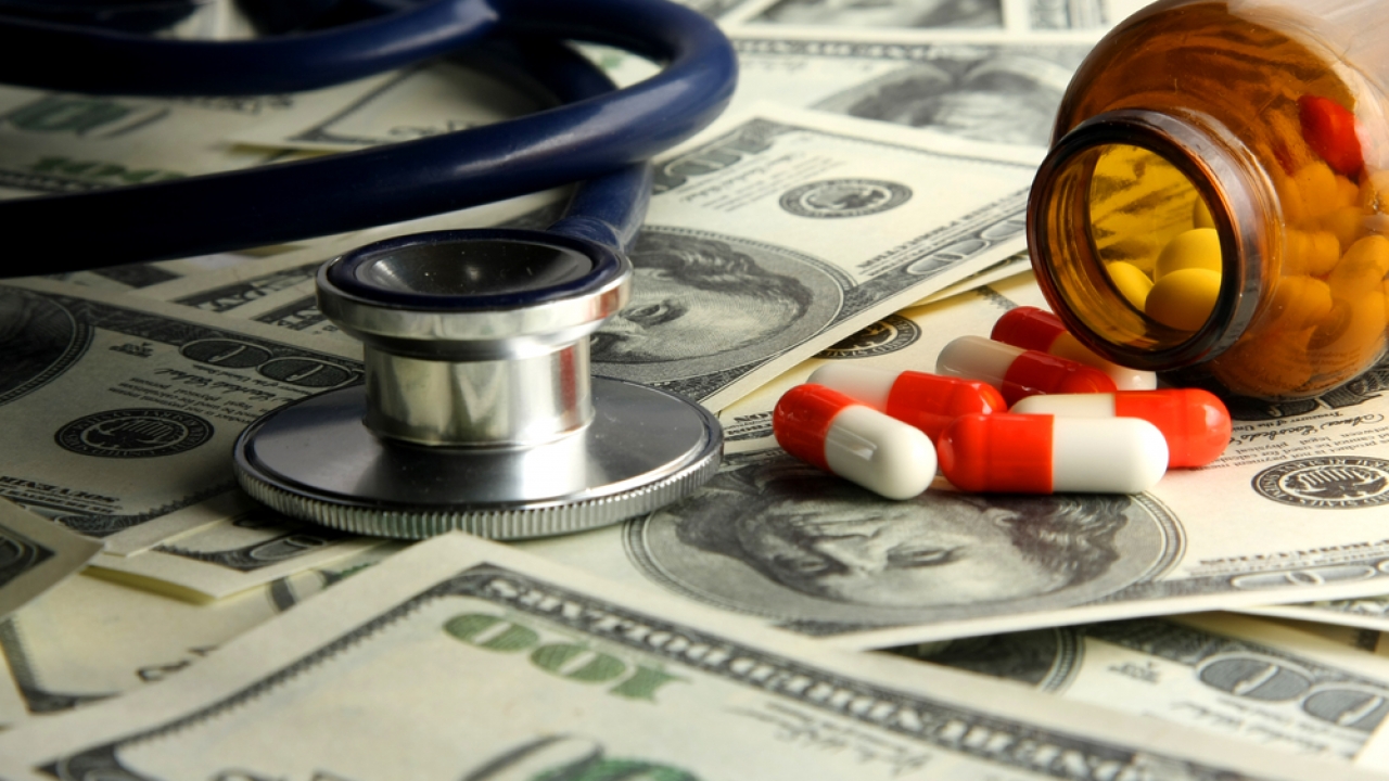 Pills and stethoscope on money.
