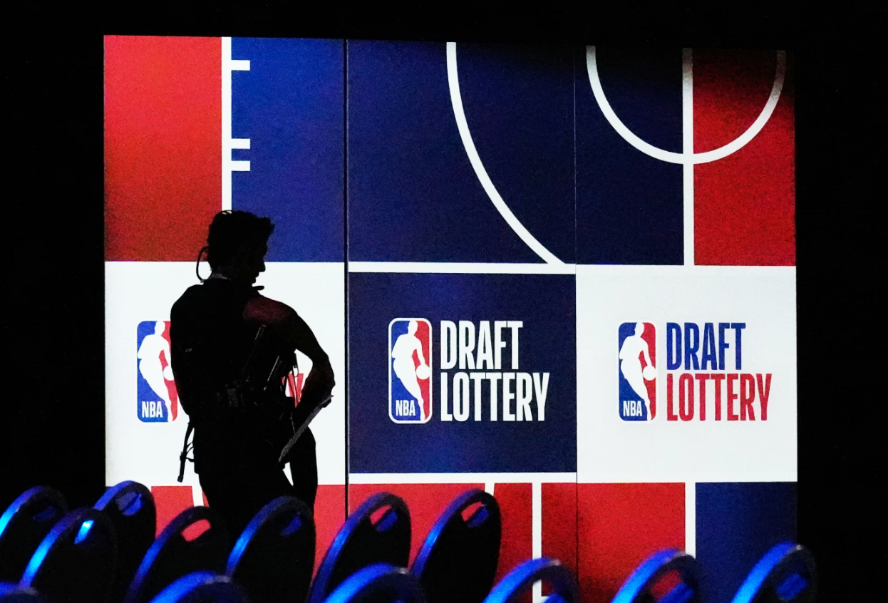 A person walks by a sign in the NBA basketball draft lottery in Chicago, Sunday, May 10, 2026.