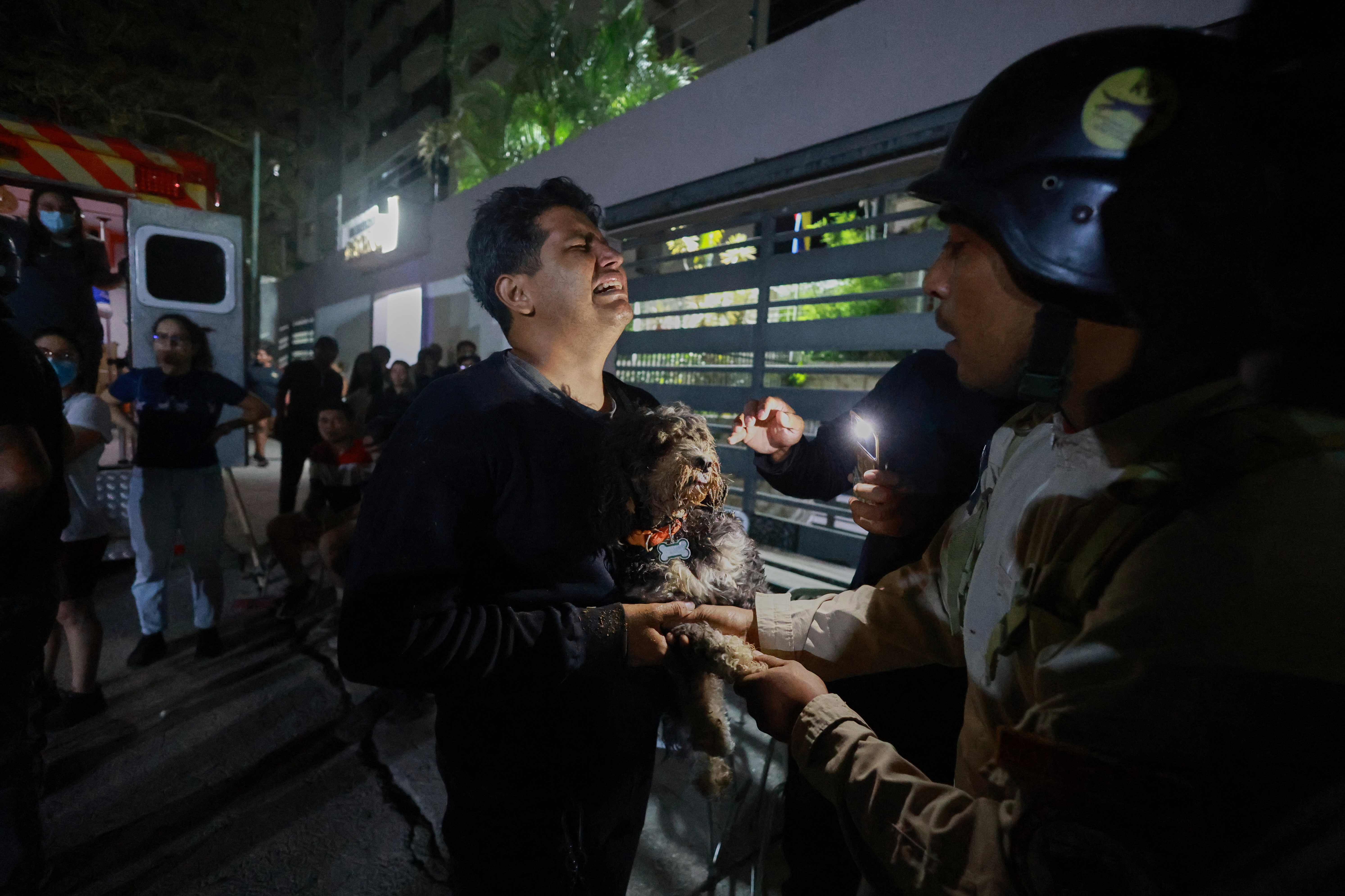 A man holding a dog cries after an earthquake in Caracas, Venezuela, Wednesday, June 24, 2026.