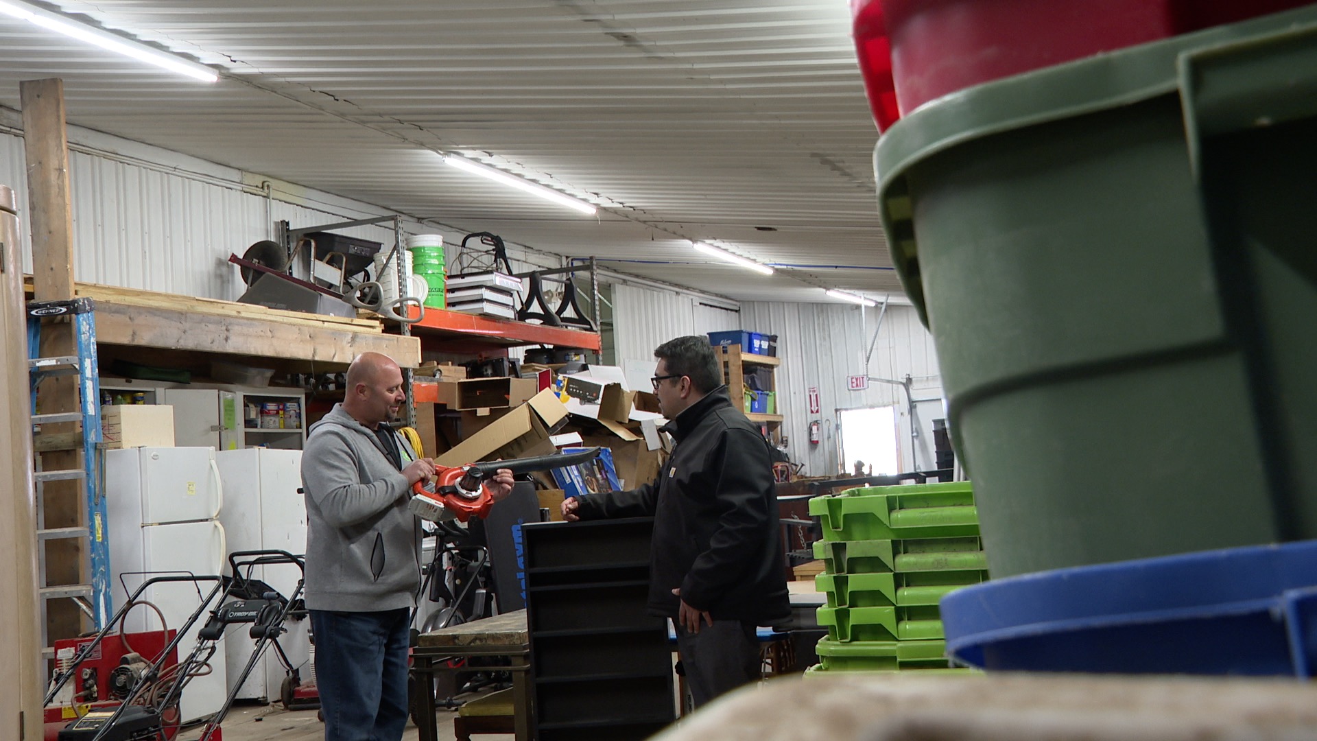 Scott Toupin shows Danny Valle a leaf blower he plans to resell at his shop
