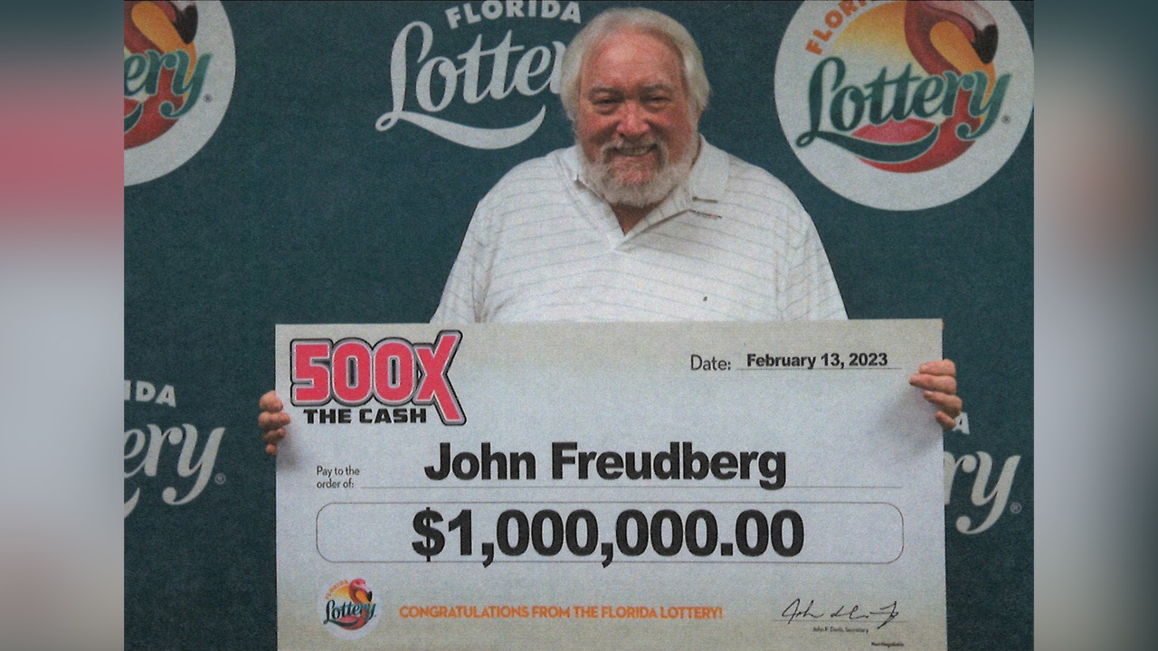 John Freudberg poses with his oversized check after claiming a $1 million prize from the 500X THE CASH Scratch-Off game at Florida Lottery Headquarters in Tallahassee.