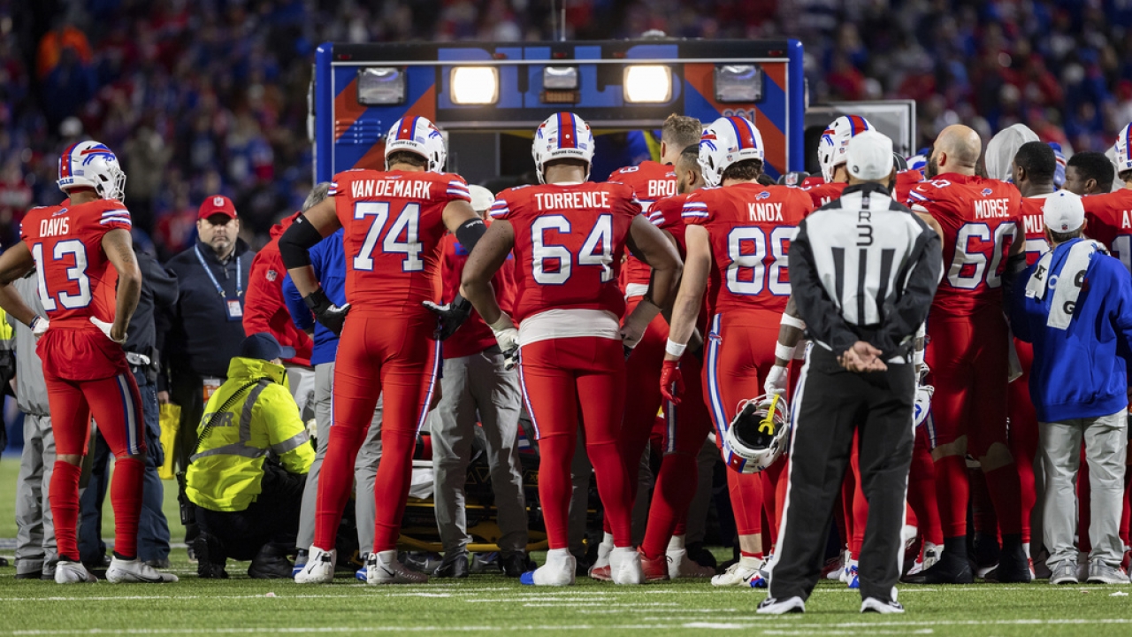 Buffalo Bills watch as running back Damien Harris is lifted into an ambulance.