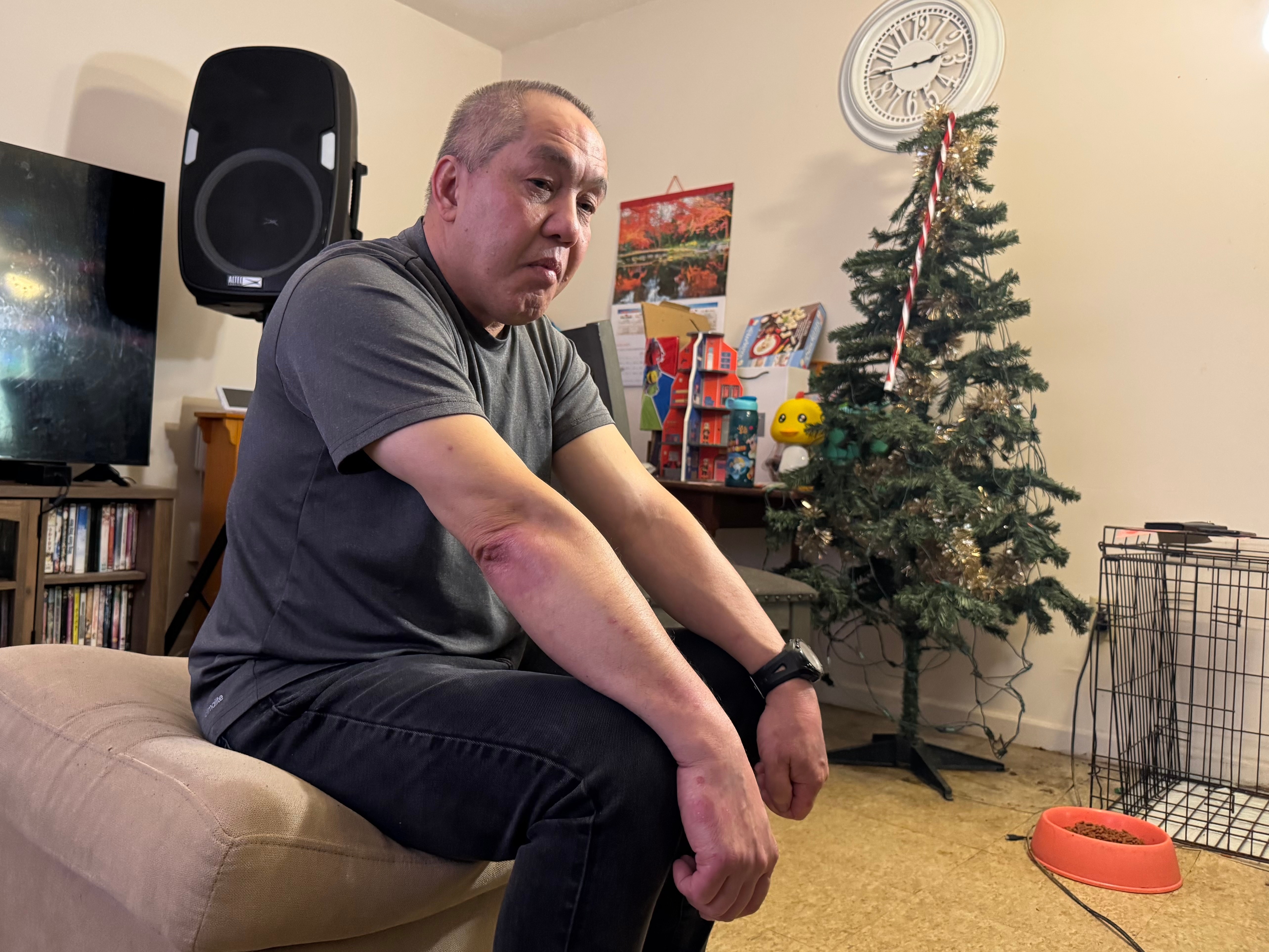 Chongly "Scott" Thao, a U.S. citizen, sits for a photo at his home Monday, Jan. 19, 2026, in St. Paul, Minn., the day after federal agents broke open his door and detained him without a warrant. 