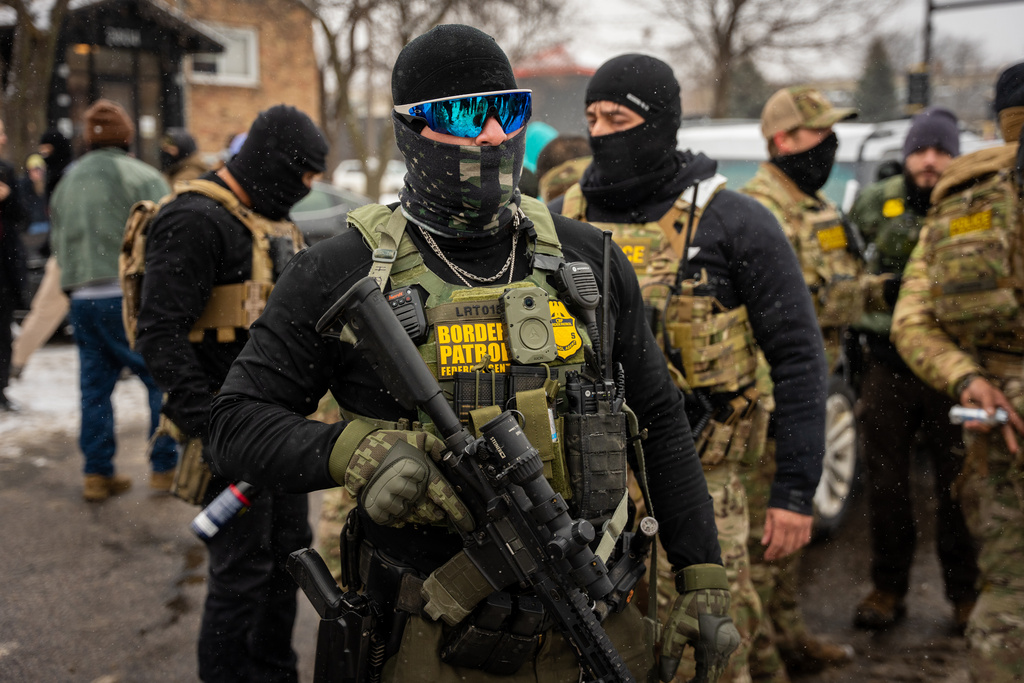 Federal agents stand guard, Wednesday, Jan. 21, 2026, in Minneapolis.