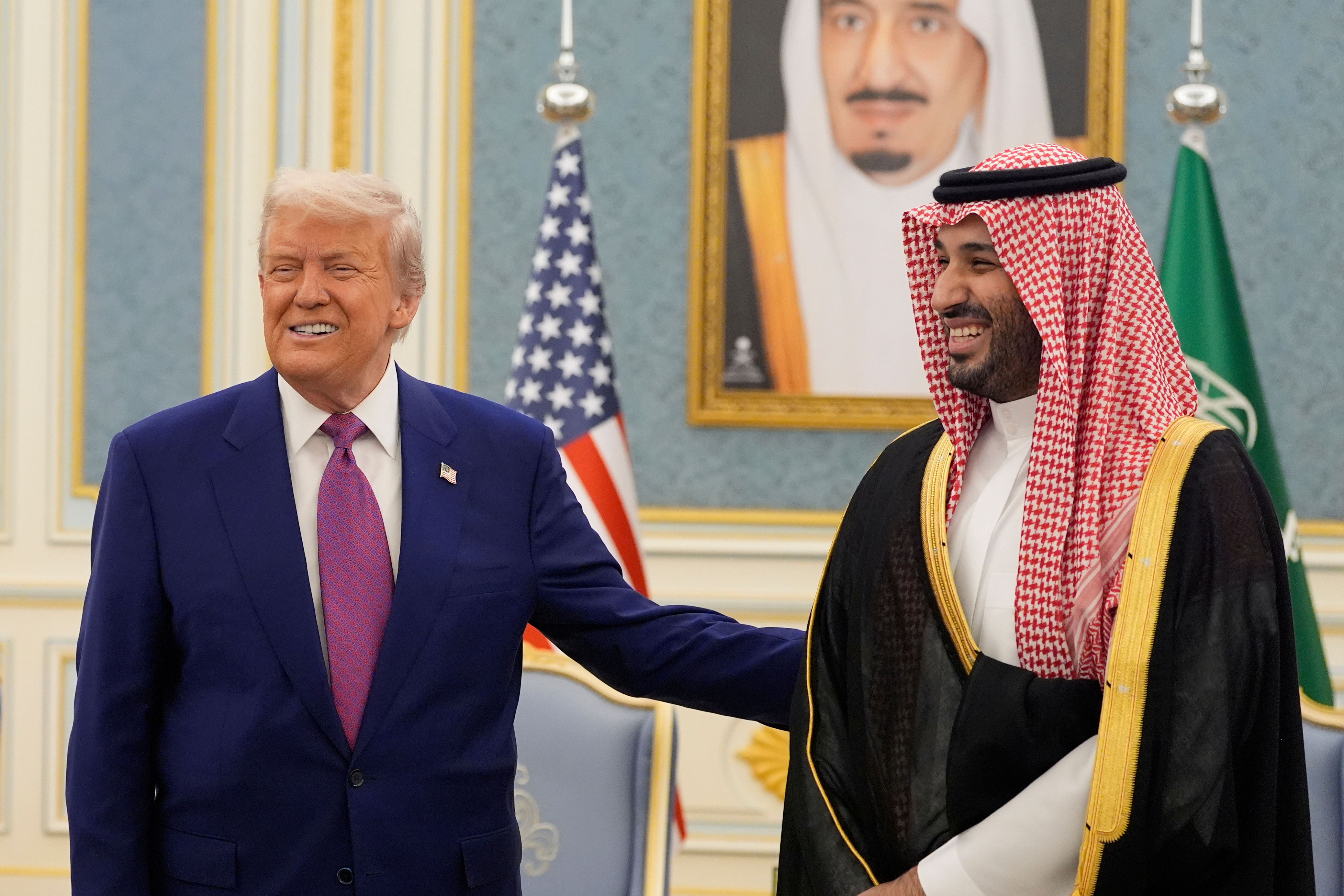 FILE - President Donald Trump and Saudi Crown Prince Mohammed bin Salman gesture as they meet delegations at the Royal Palace in Riyadh, Saudi Arabia, May 13, 2025. 