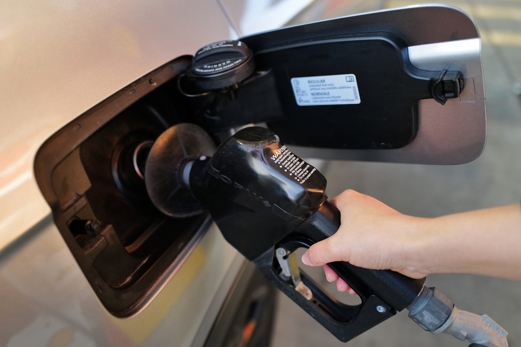 A person fills up her vehicle's gas tank at a gas station in Buffalo Grove, Ill., Thursday, March 19, 2026. (AP Photo/Nam Y. Huh)