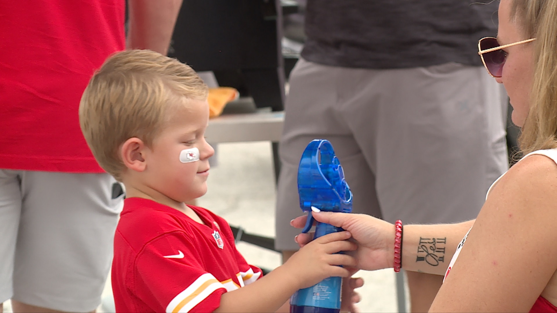 Chiefs tailgate kid with fan.jpg
