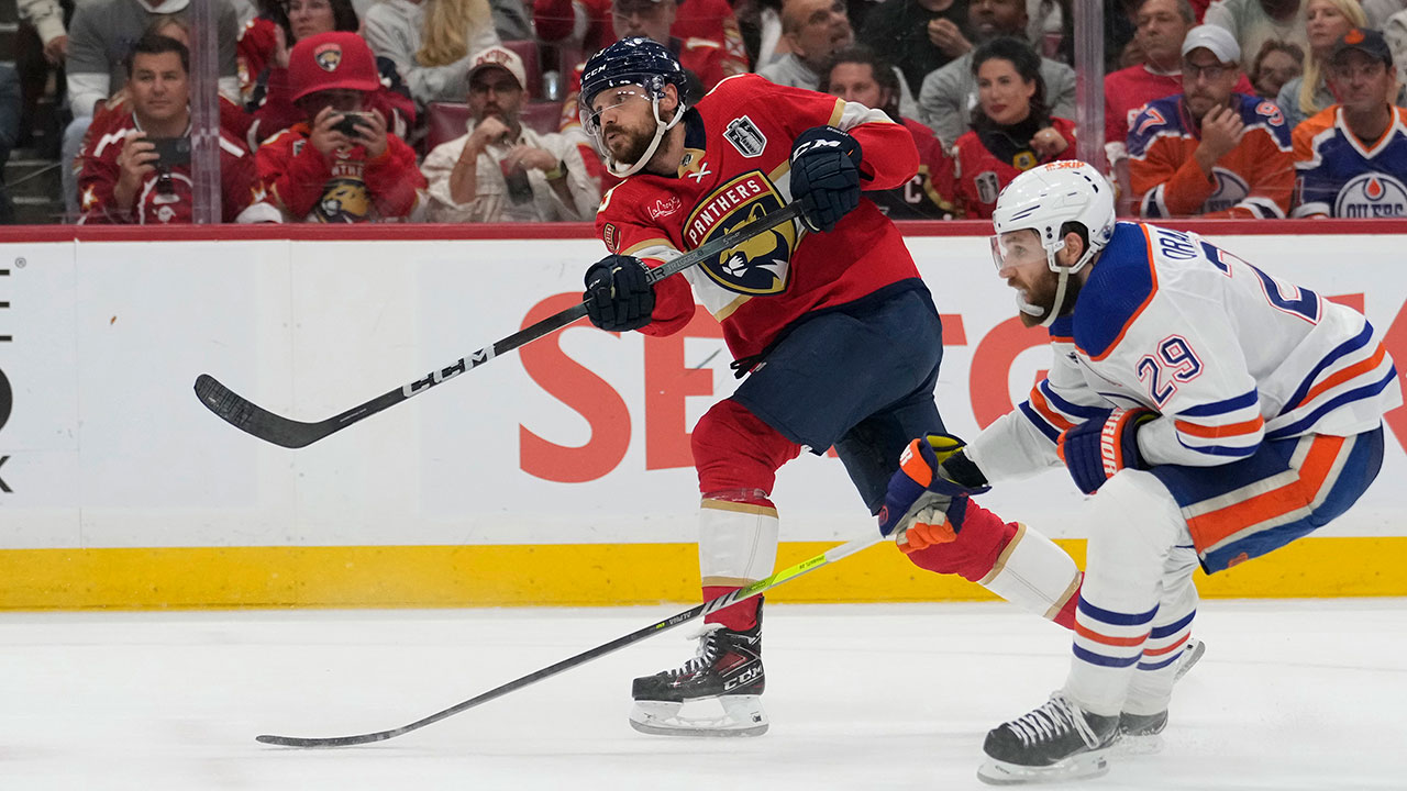 Florida Panthers center Sam Reinhart, left, aims the puck for a goal as Edmonton Oilers center Leon Draisaitl (29) attempts to defend during the second period of Game 7 of the NHL hockey Stanley Cup Final, Monday, June 24, 2024, in Sunrise, Fla.