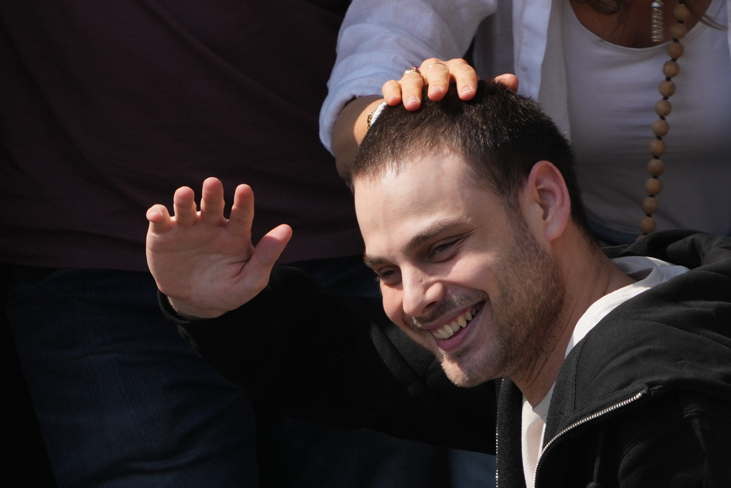 Freed Israeli hostage Alon Ohel gestures from a van as he arrives at Beilinson hospital in Petah Tikva, Israel, after he was released from Hamas captivity.