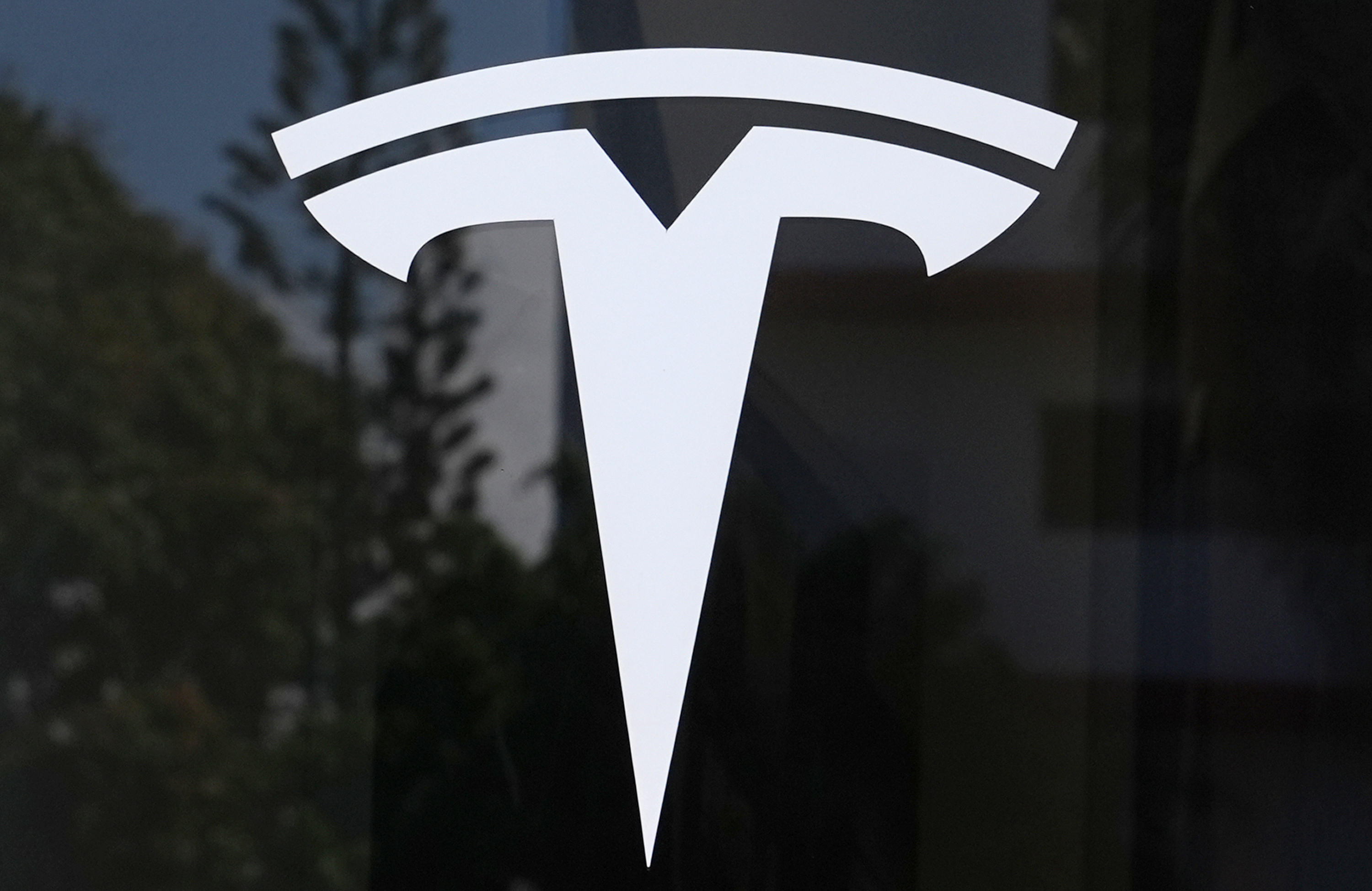 FILE - The Tesla logo is displayed at a Tesla dealership.
