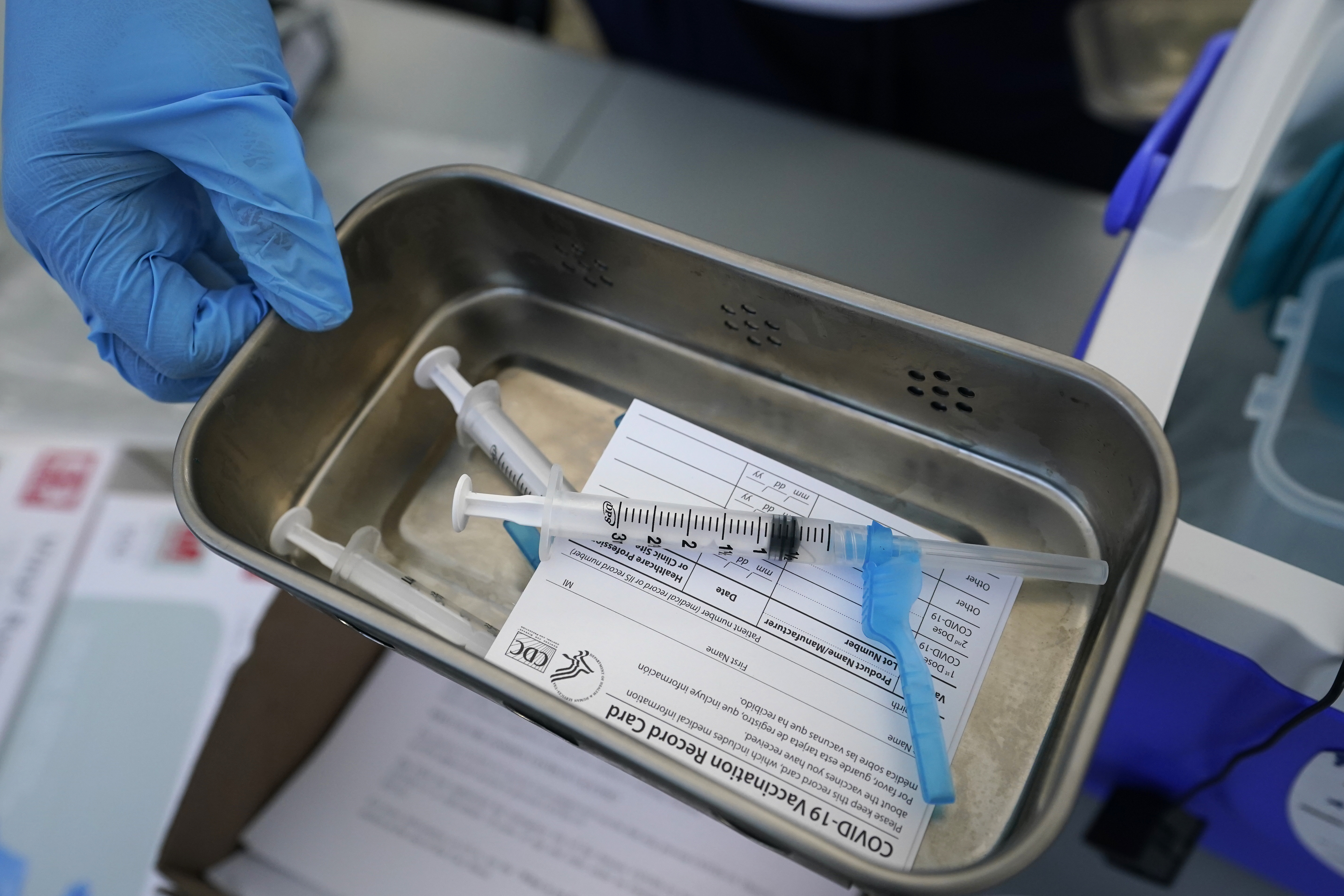COVID-19 vaccine card and syringes