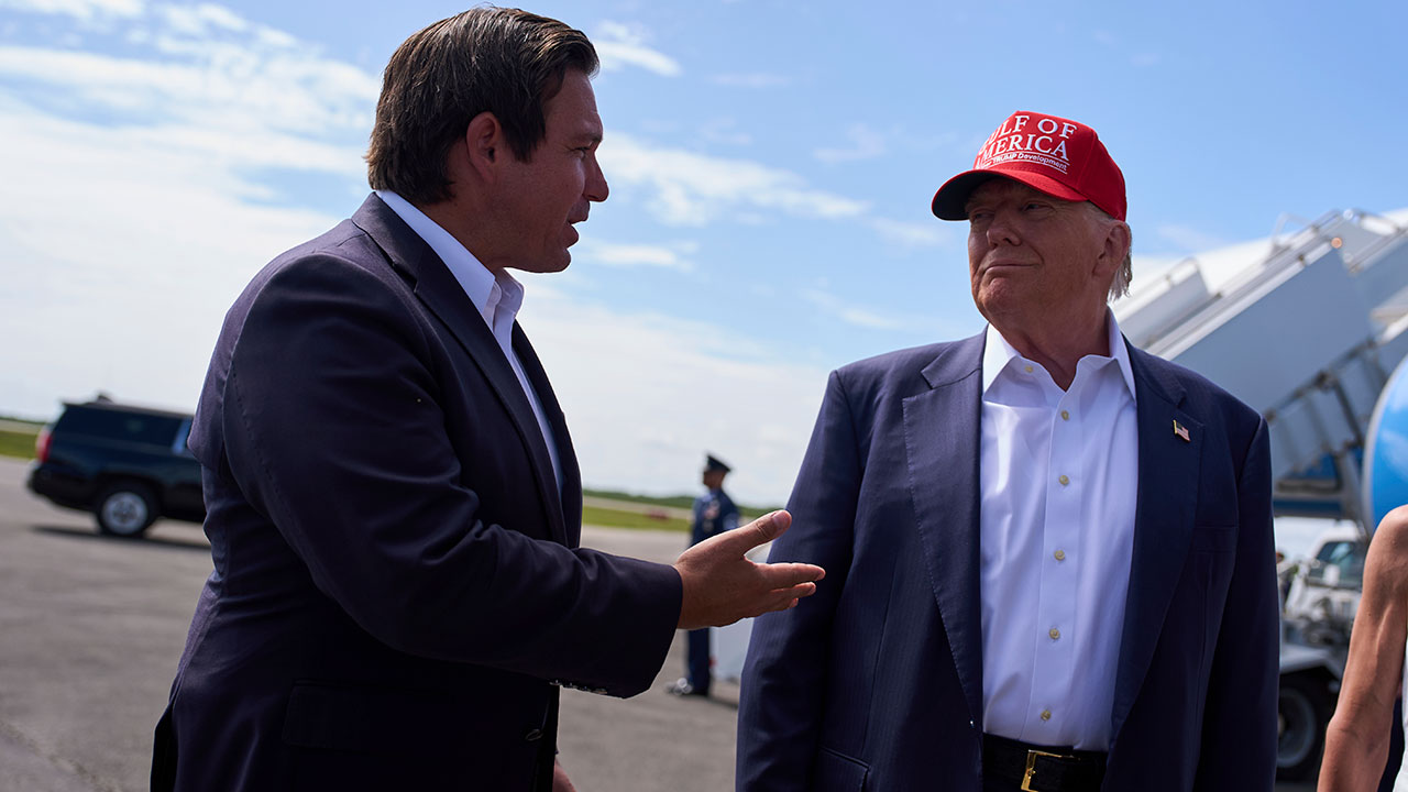 President Donald Trump listens as Gov. Ron DeSantis, R-Fla., speaks with reporters after arriving at Dade-Collier Training and Transition Airport, Tuesday, July 1, 2025, in Ochopee, Fla. 